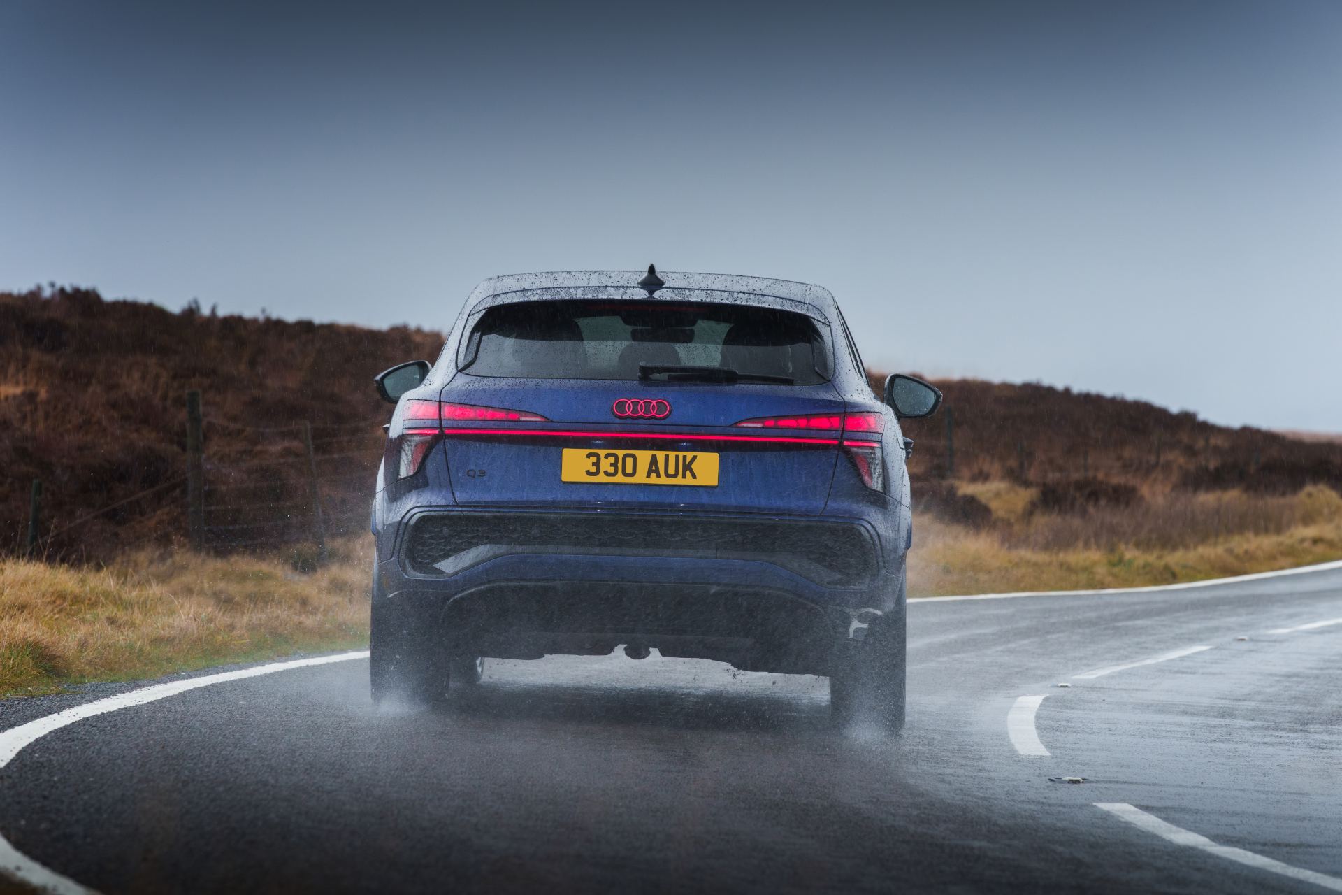 2026 audi q3 sportback e hybrid driving rear wet bend blue