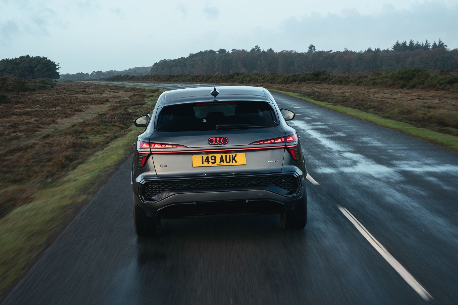 2026 audi q3 sportback driving rear wet road grey