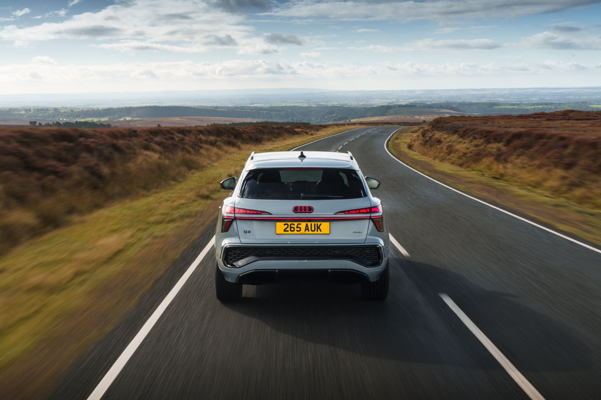 2026 audi q3 driving rear moorland road silver