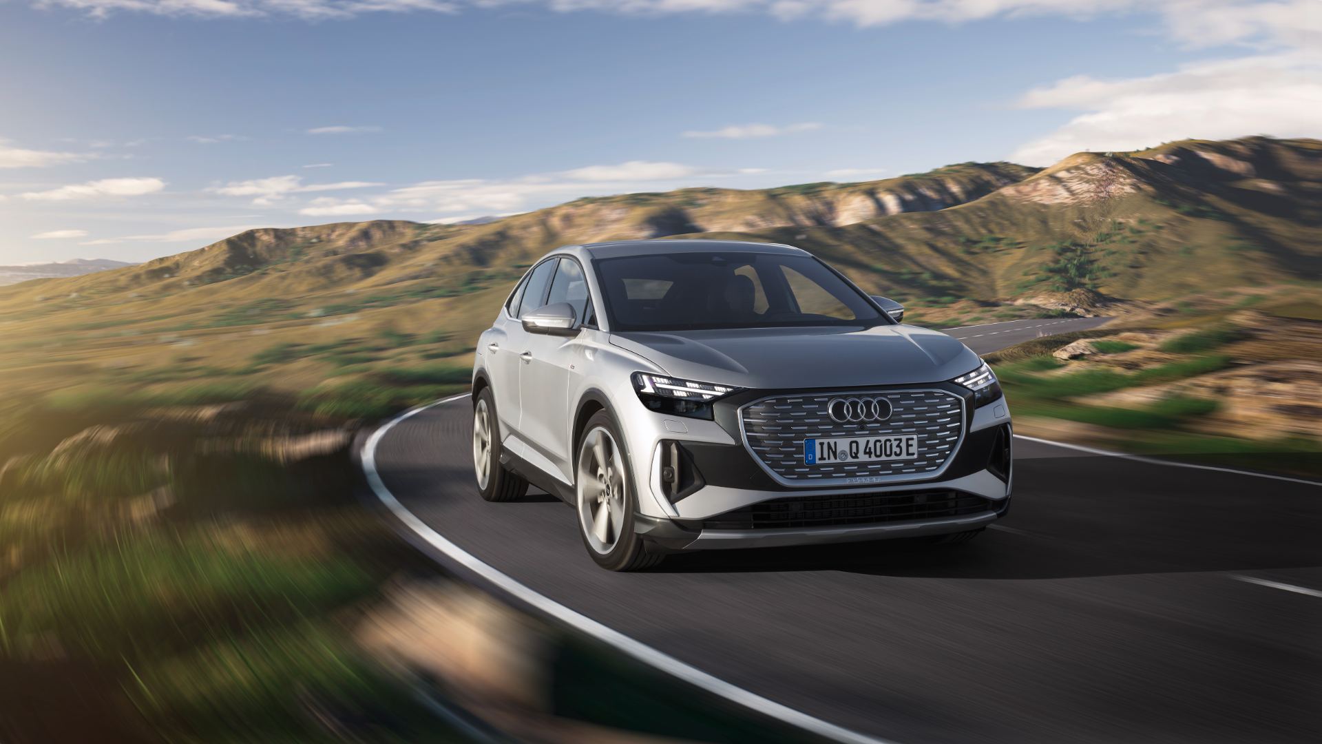 2026 audi q4 sportback e tron driving front three quarter hills silver
