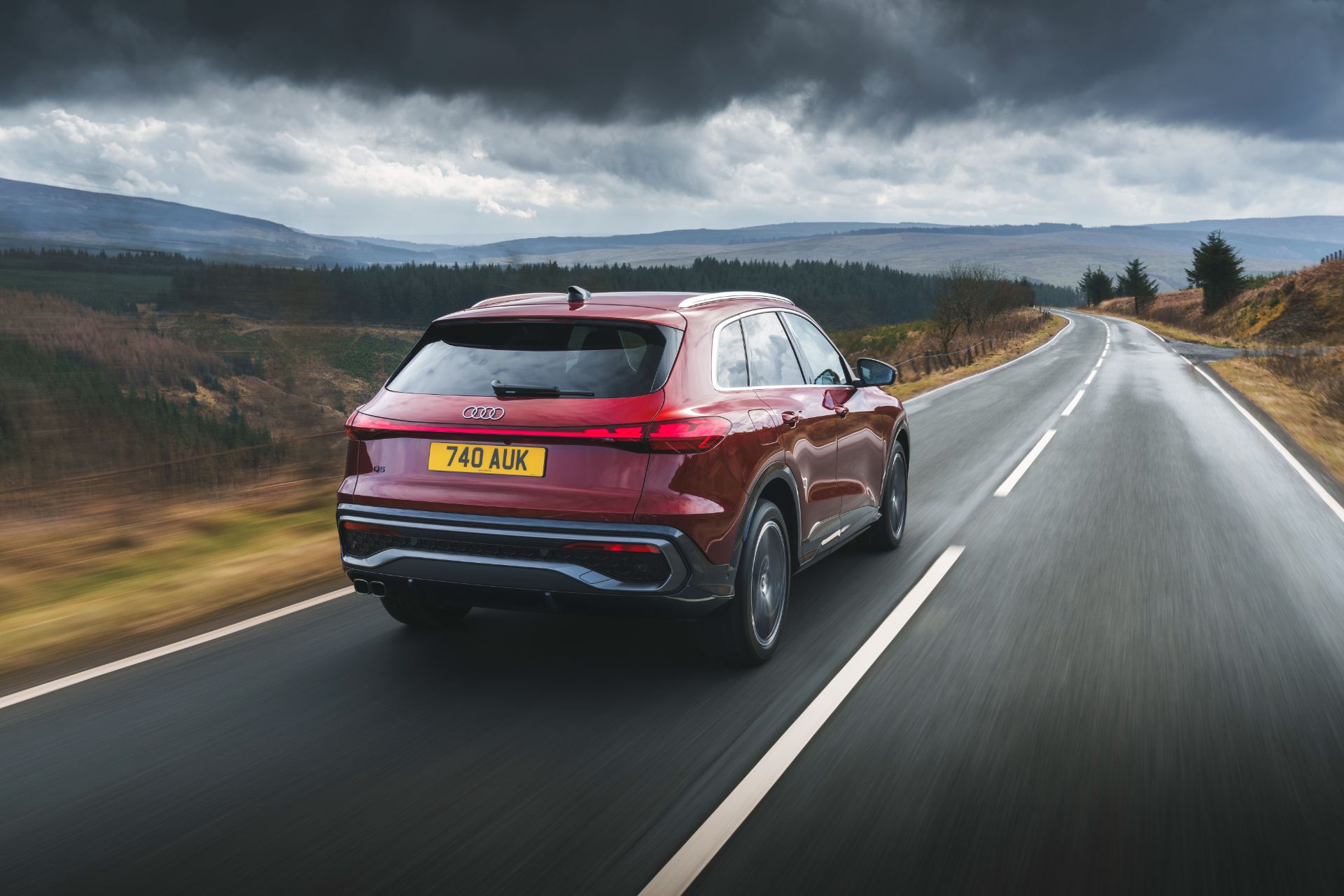 2026 audi q5 suv driving rear three quarter red
