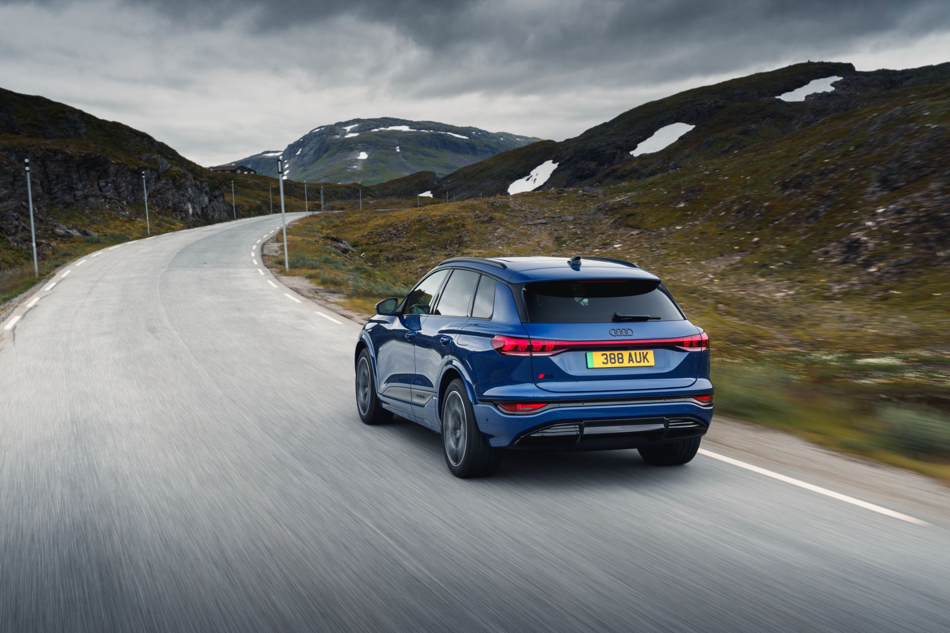 2026 audi q6 e tron driving rear three quarter blue