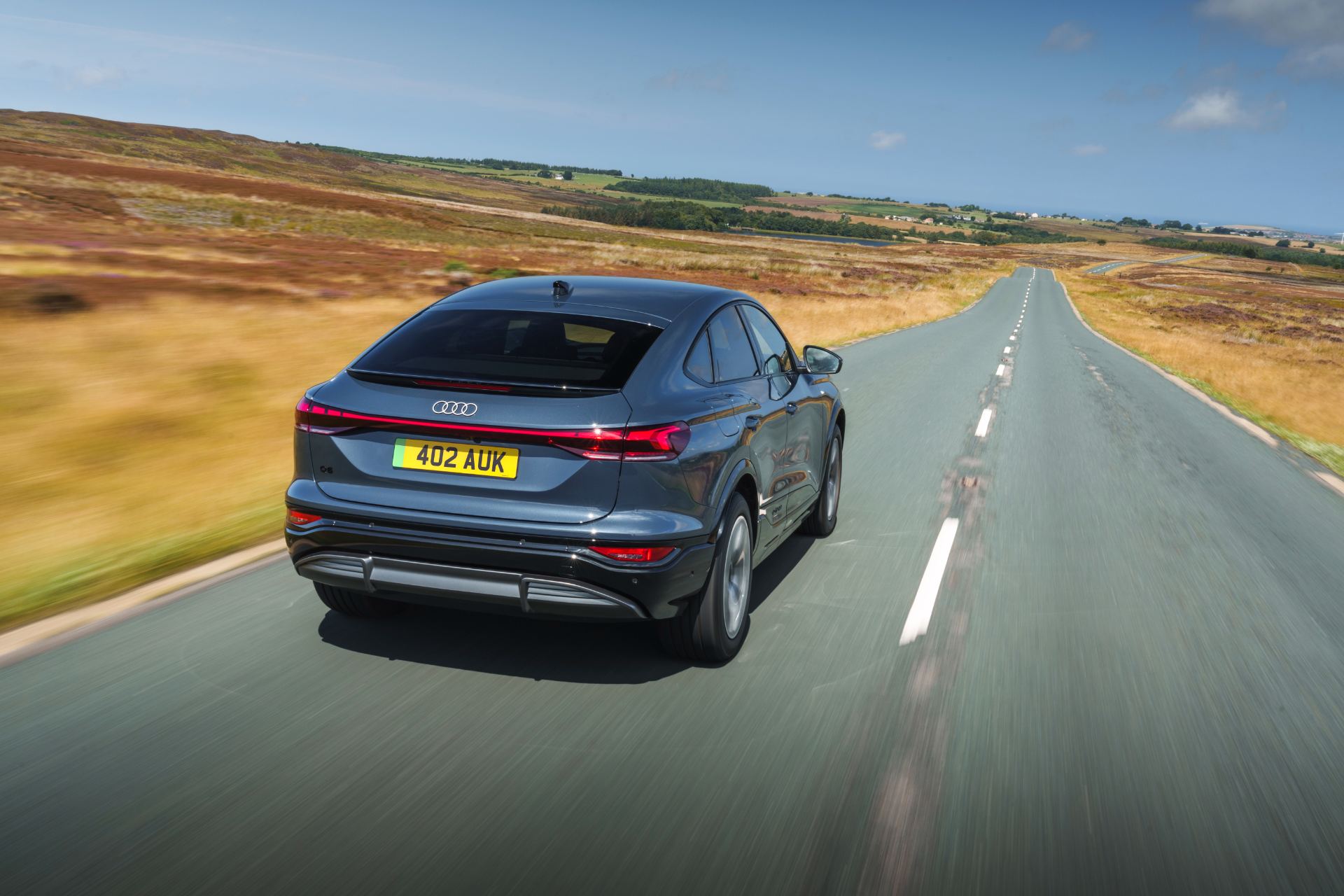 2026 audi q6 sportback e tron driving rear straight road grey