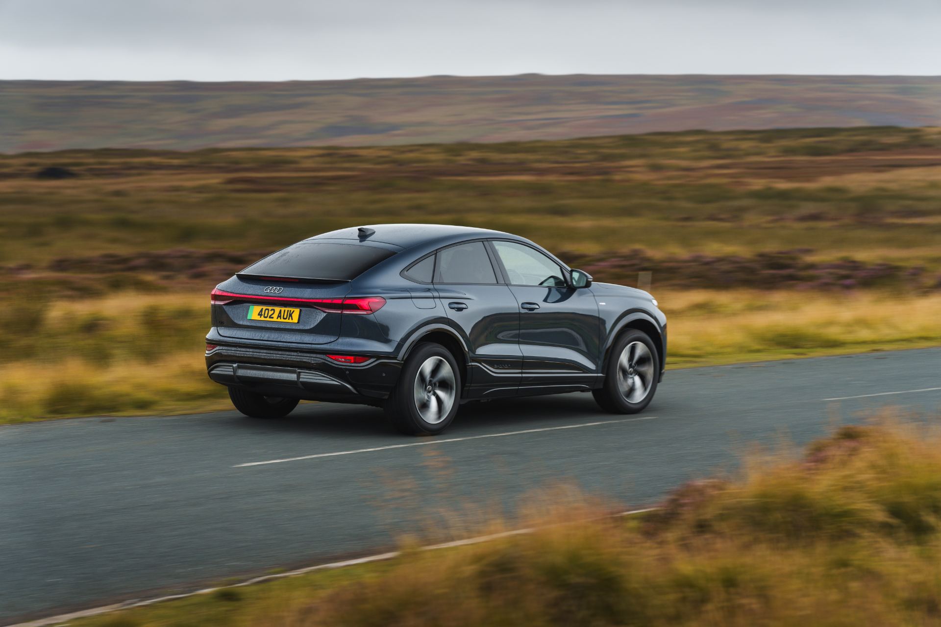 2026 audi q6 sportback e tron driving rear three quarter grey