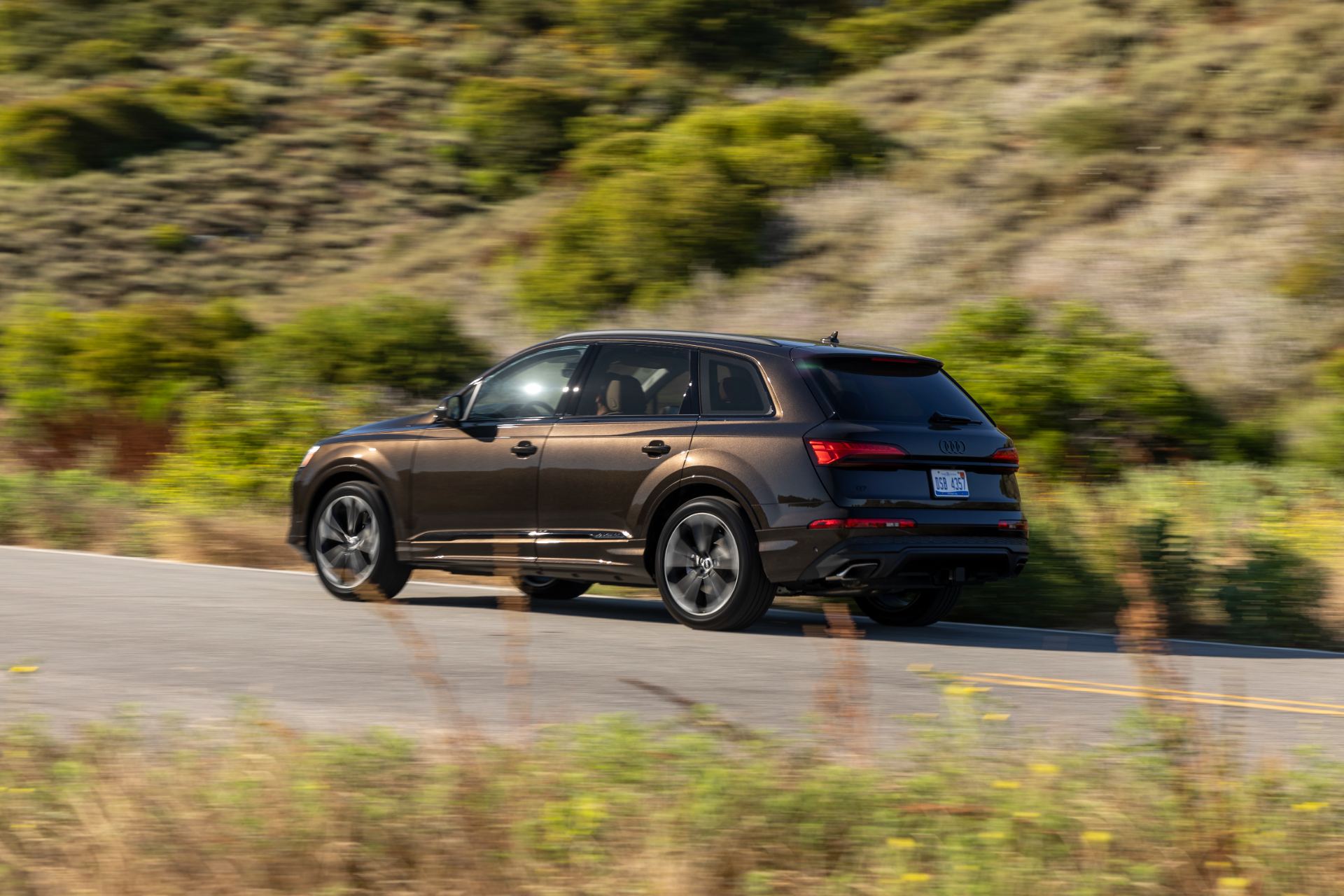 2026 audi q7 driving rear three quarter brown