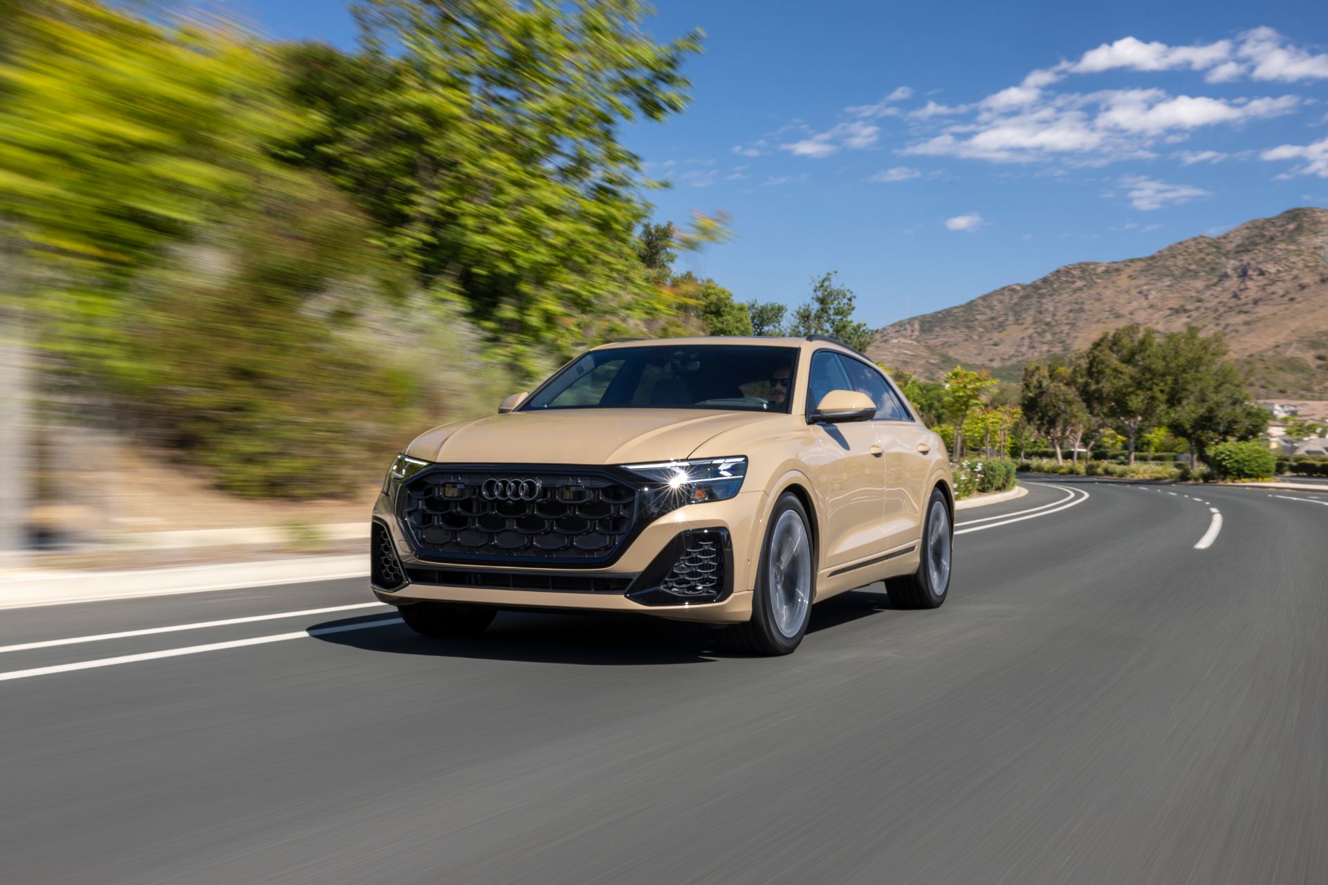 2027 audi q8 driving front three quarter hills beige