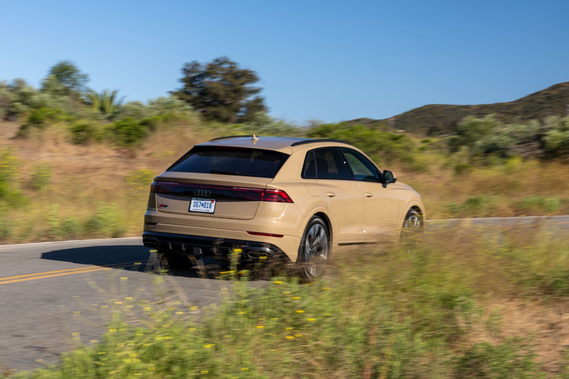 2027 audi q8 driving rear three quarter beige