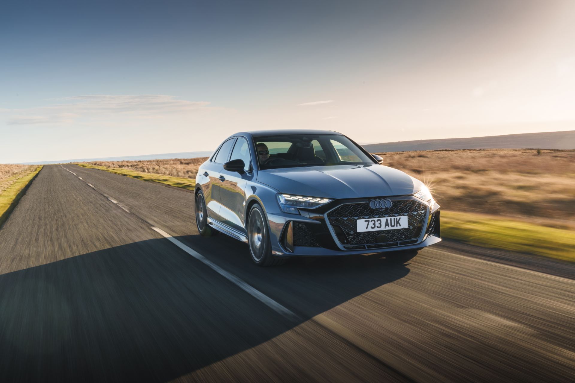 2025 audi rs 3 saloon driving front three quarter moorland road grey
