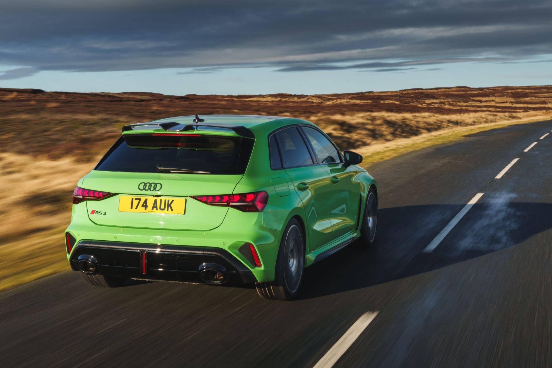 2025 audi rs 3 sportback driving rear three quarter moorland road green