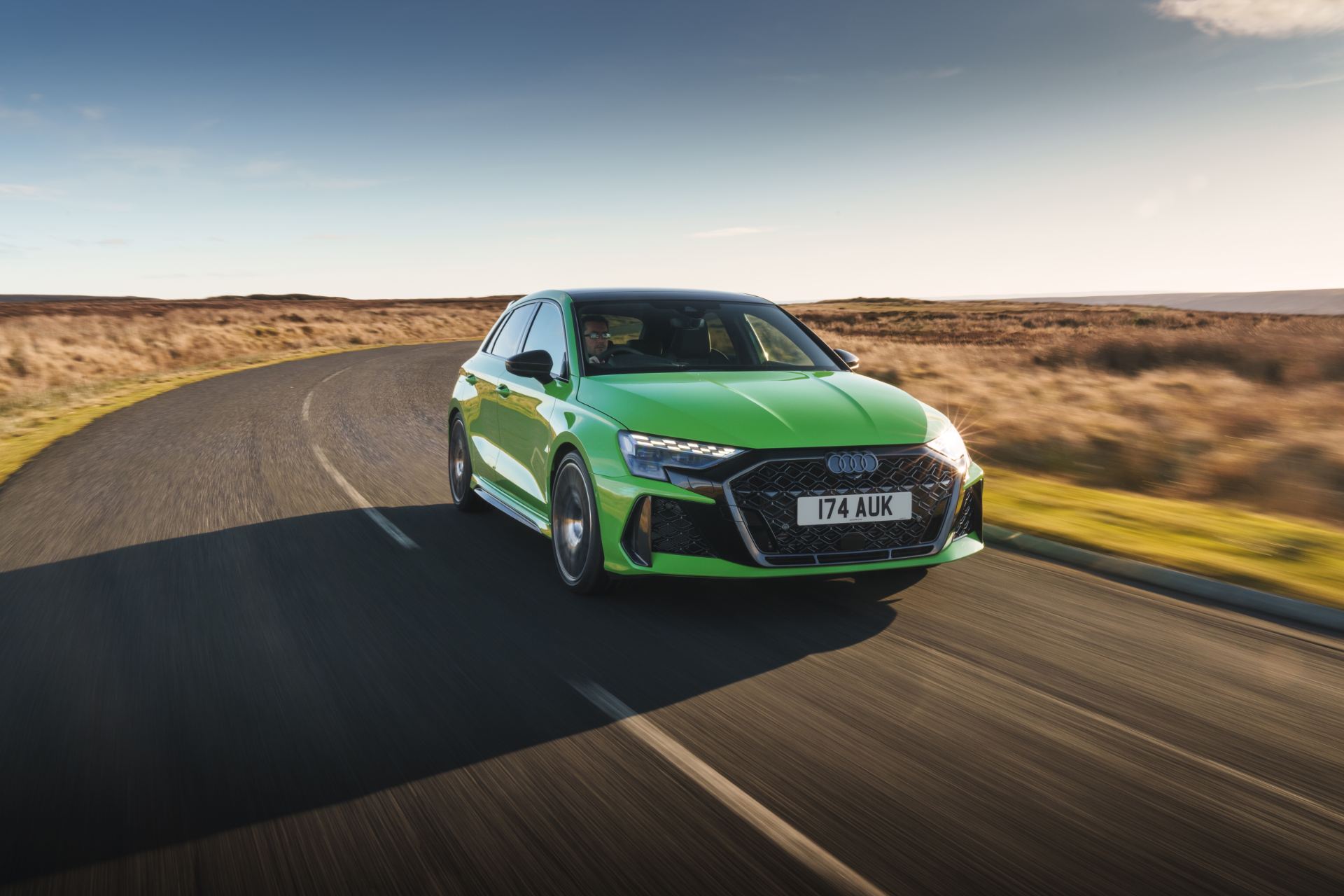 2025 audi rs 3 sportback driving front three quarter moorland road green