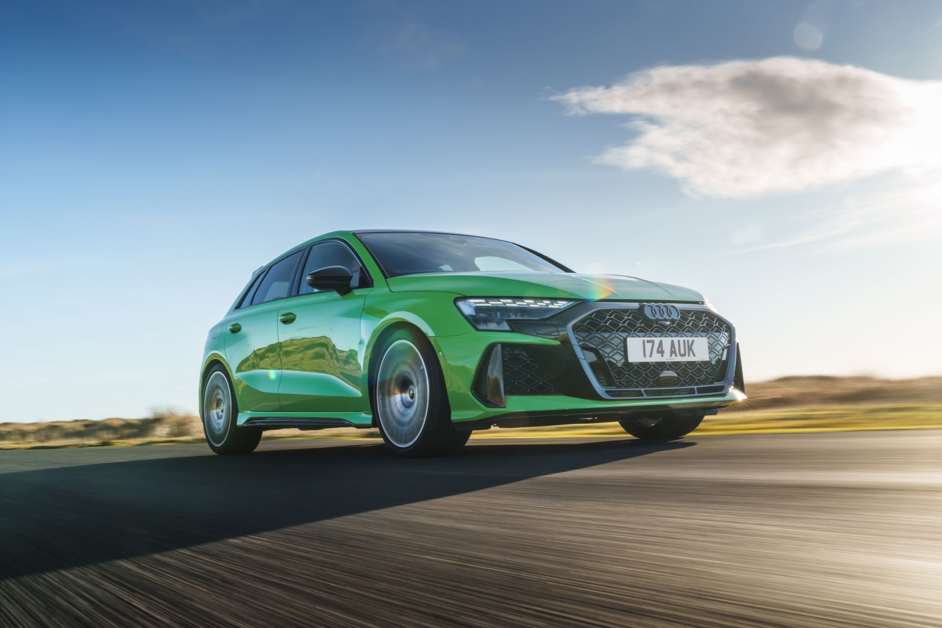 2025 audi rs 3 sportback driving front three quarter low angle green