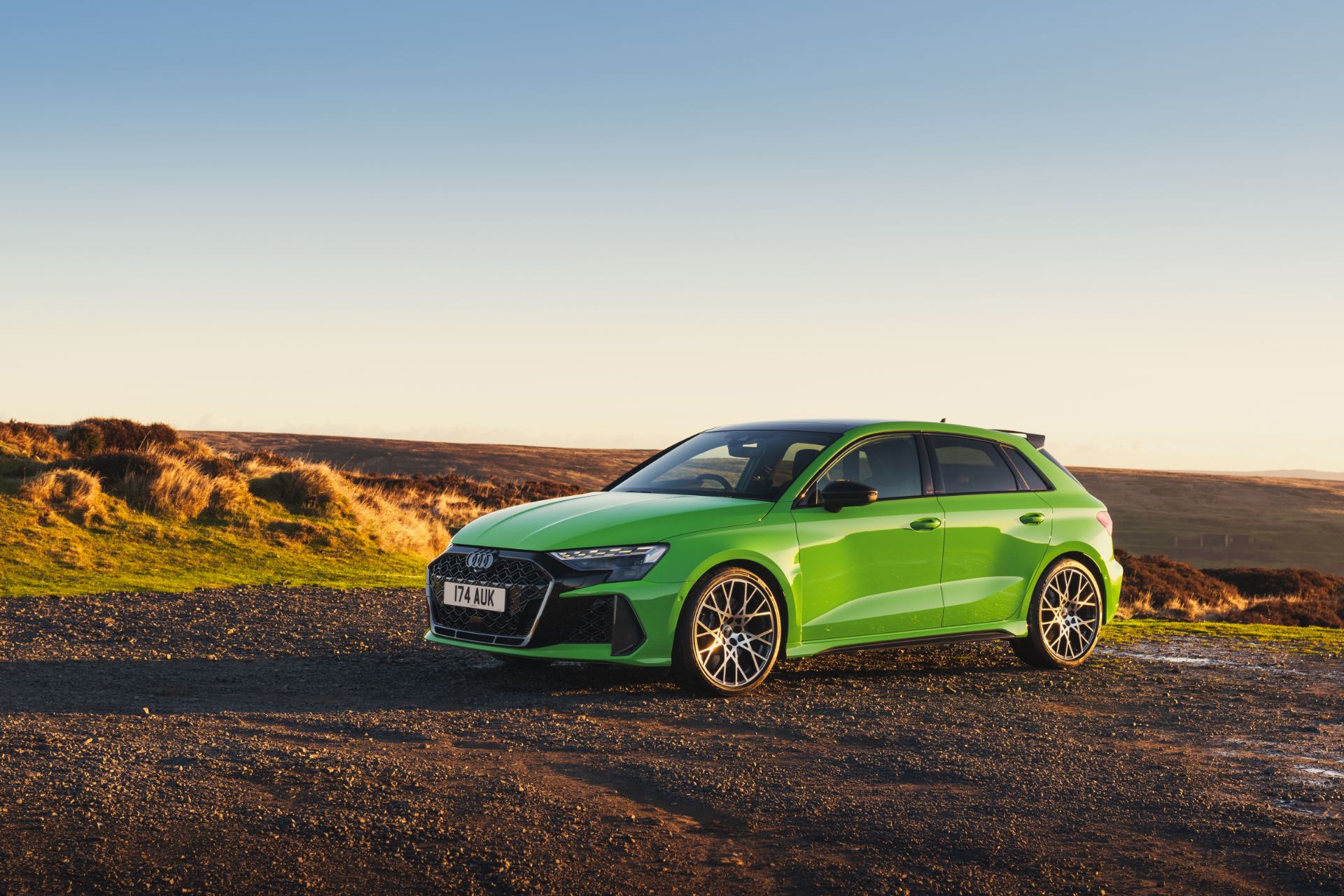 2025 audi rs 3 sportback front three quarter distant sunset green