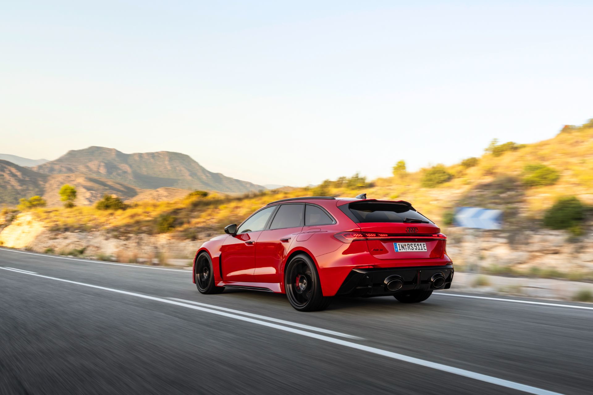 2026 audi rs 5 avant driving rear three quarter mountain road red