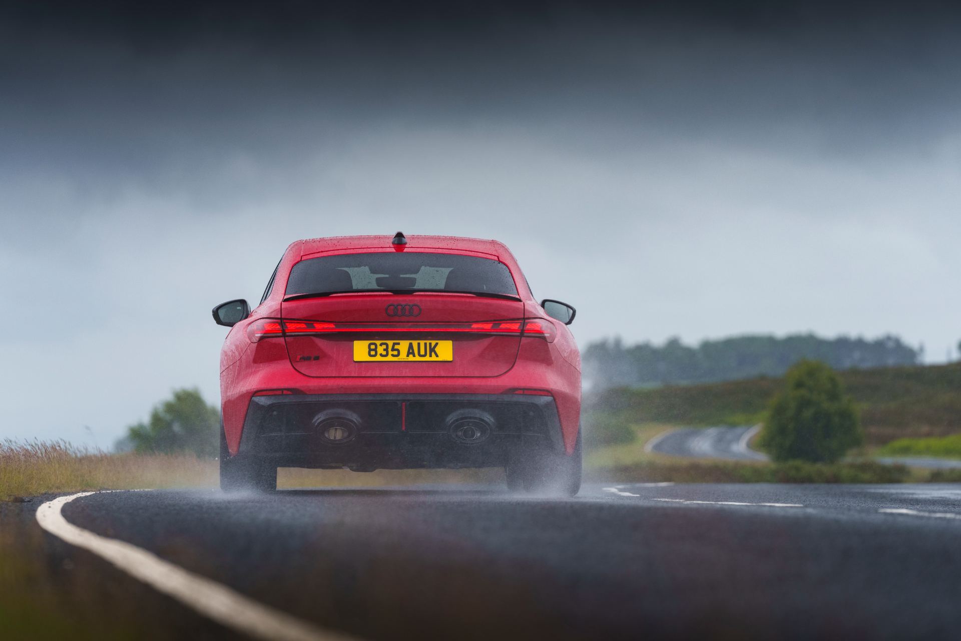 2026 audi rs 5 saloon driving rear wet bend red
