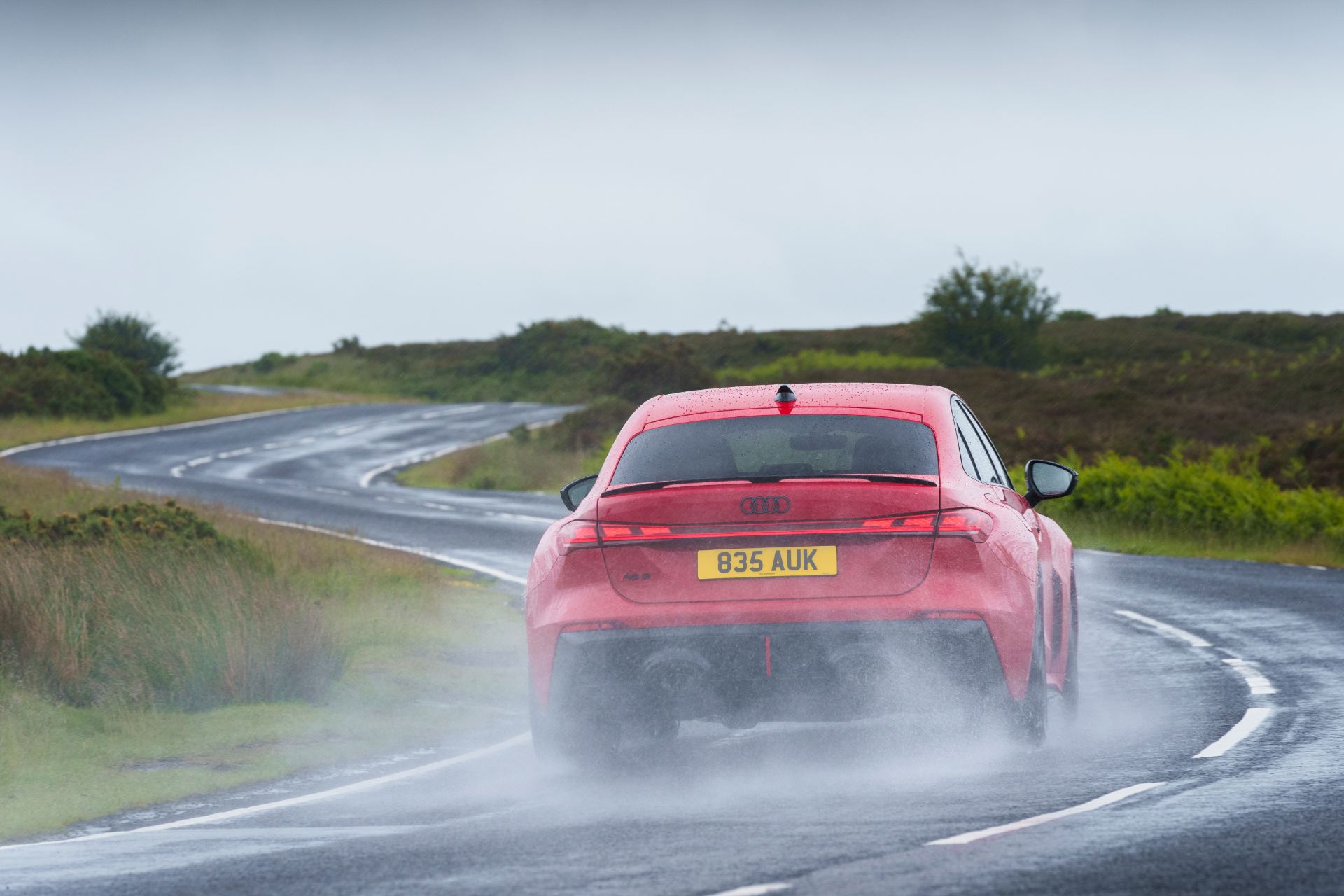 2026 audi rs 5 saloon driving rear wet winding road red