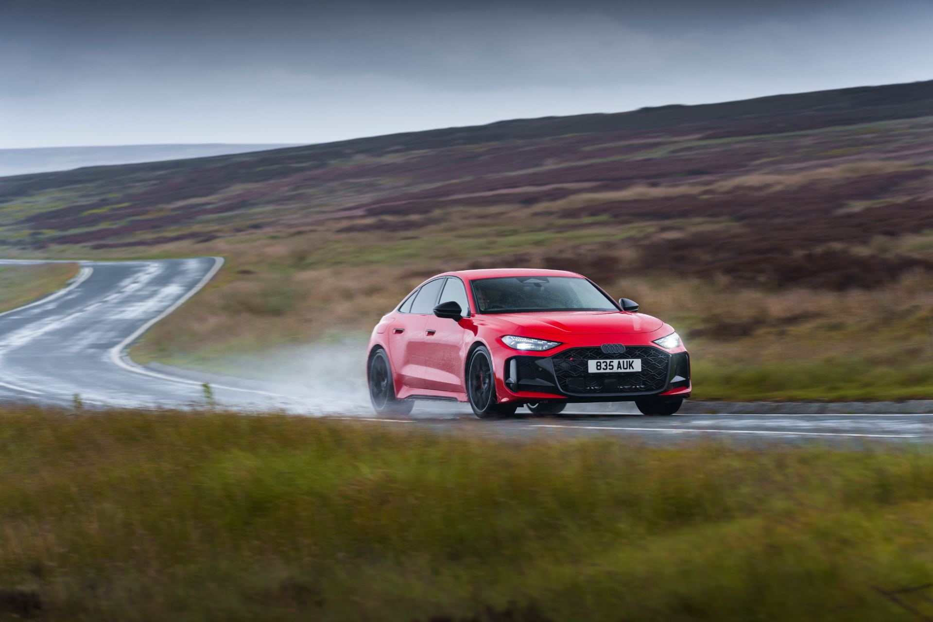 2026 audi rs 5 saloon driving front three quarter wet bend red