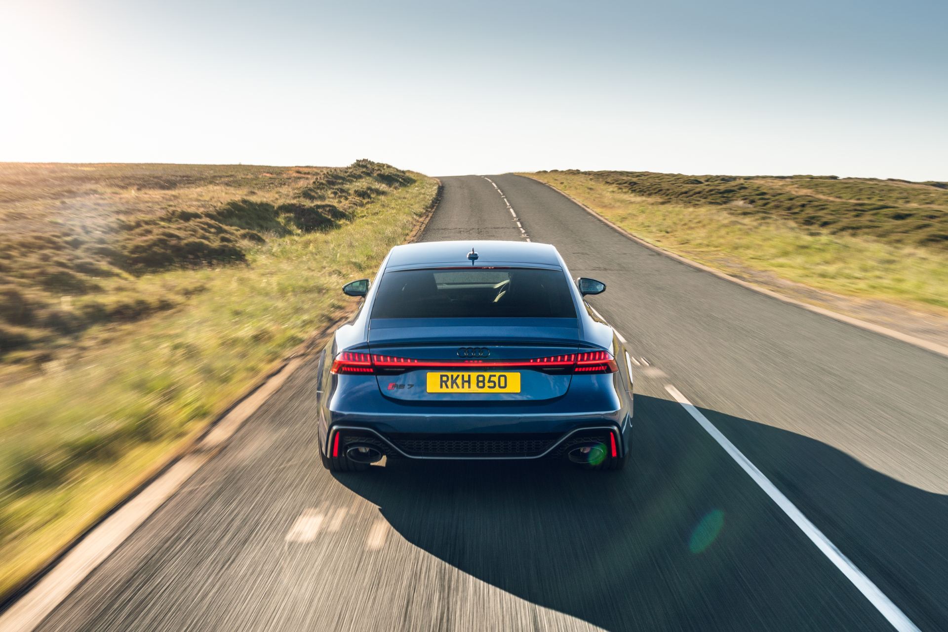 2025 audi rs 7 sportback performance driving rear moorland road blue