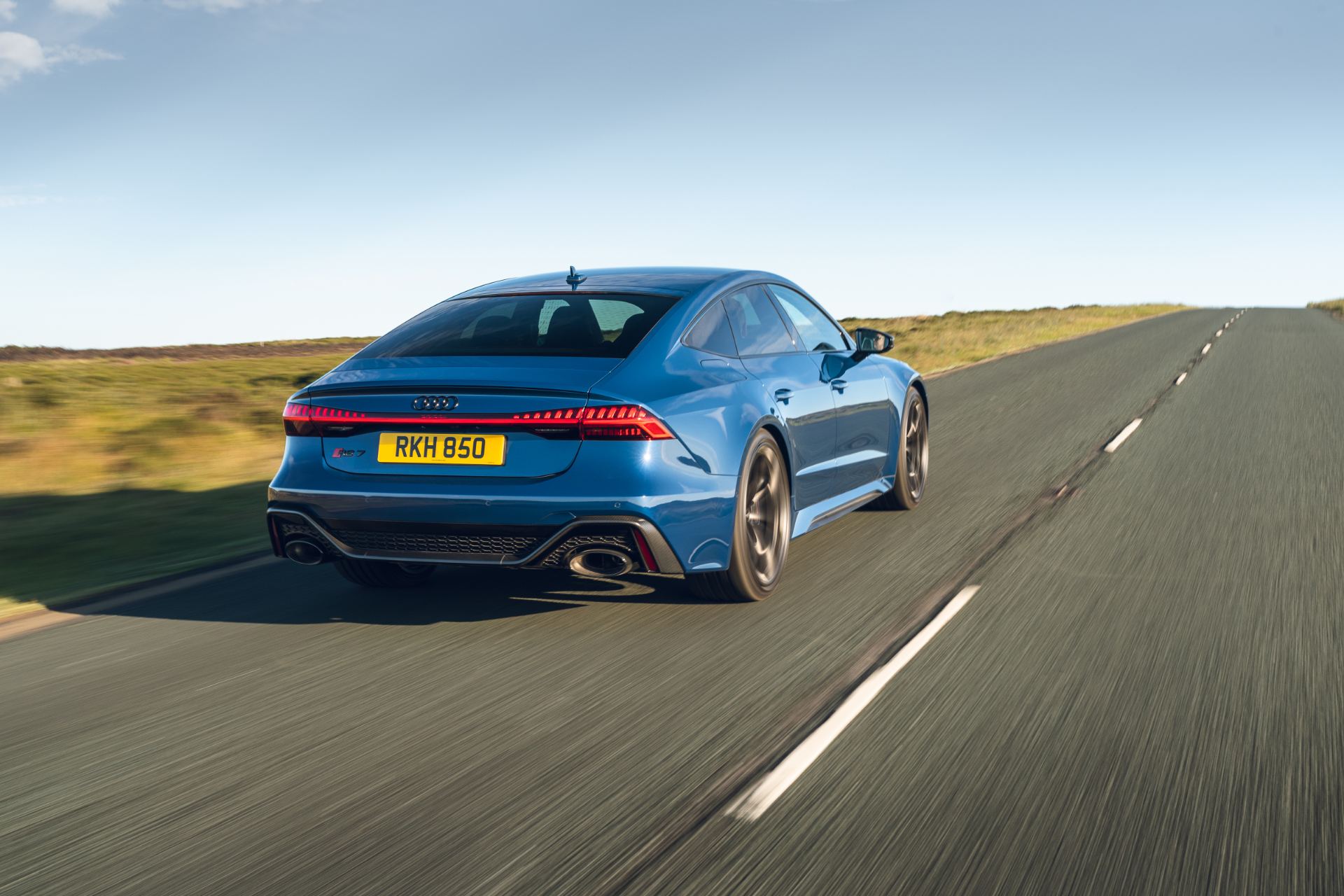 2025 audi rs 7 sportback performance driving rear three quarter road blue
