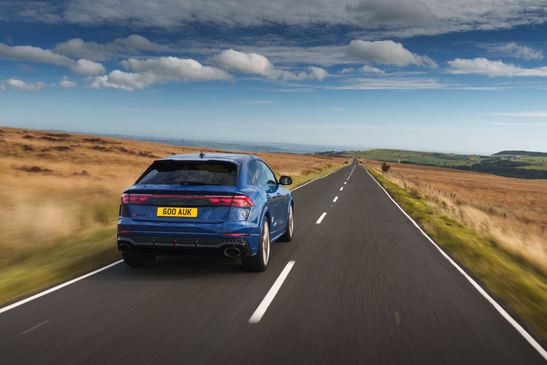 2026 audi rs q8 driving rear straight road blue
