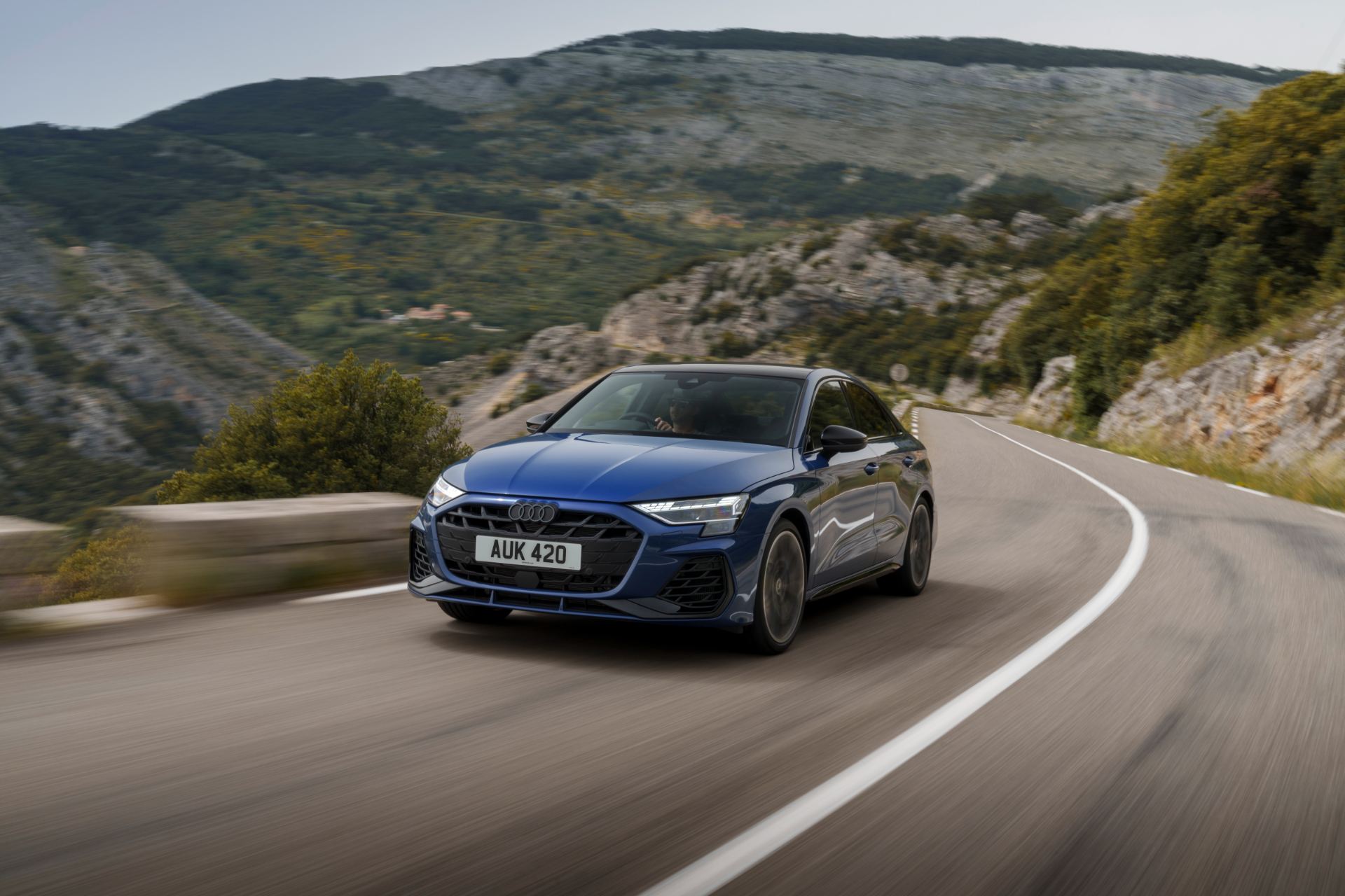 2025 audi s3 saloon driving front three quarter mountain road blue