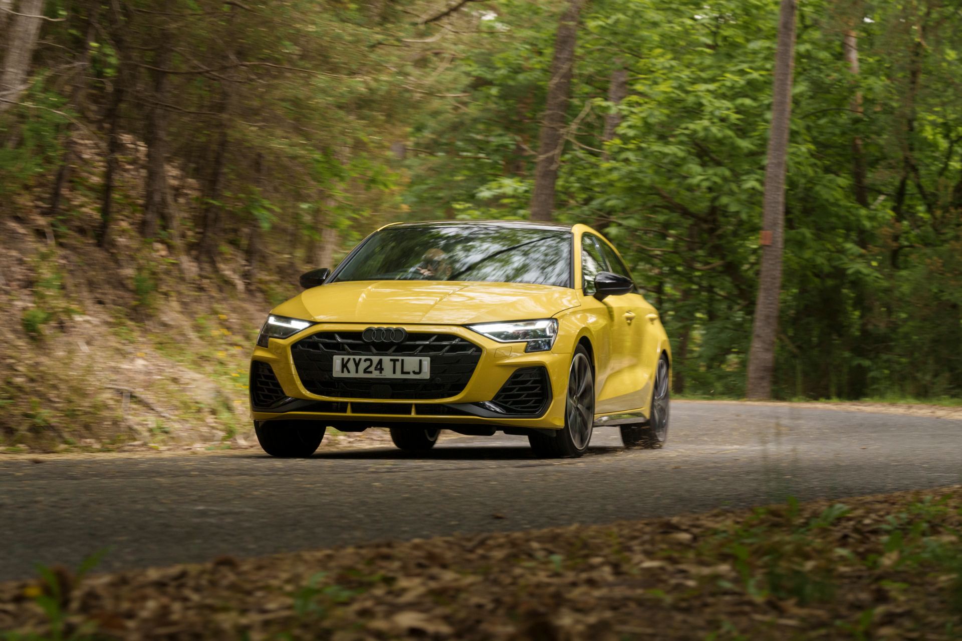 2025 audi s3 sportback driving front three quarter forest yellow