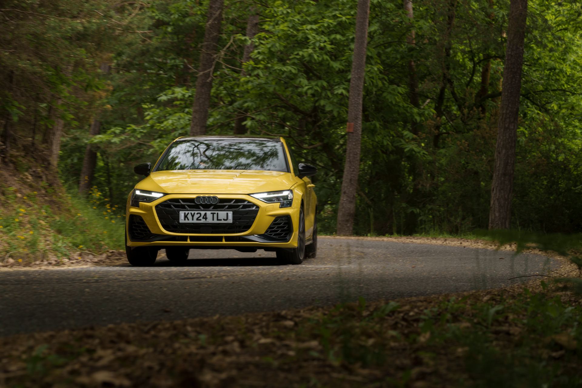 2025 audi s3 sportback driving front forest road yellow