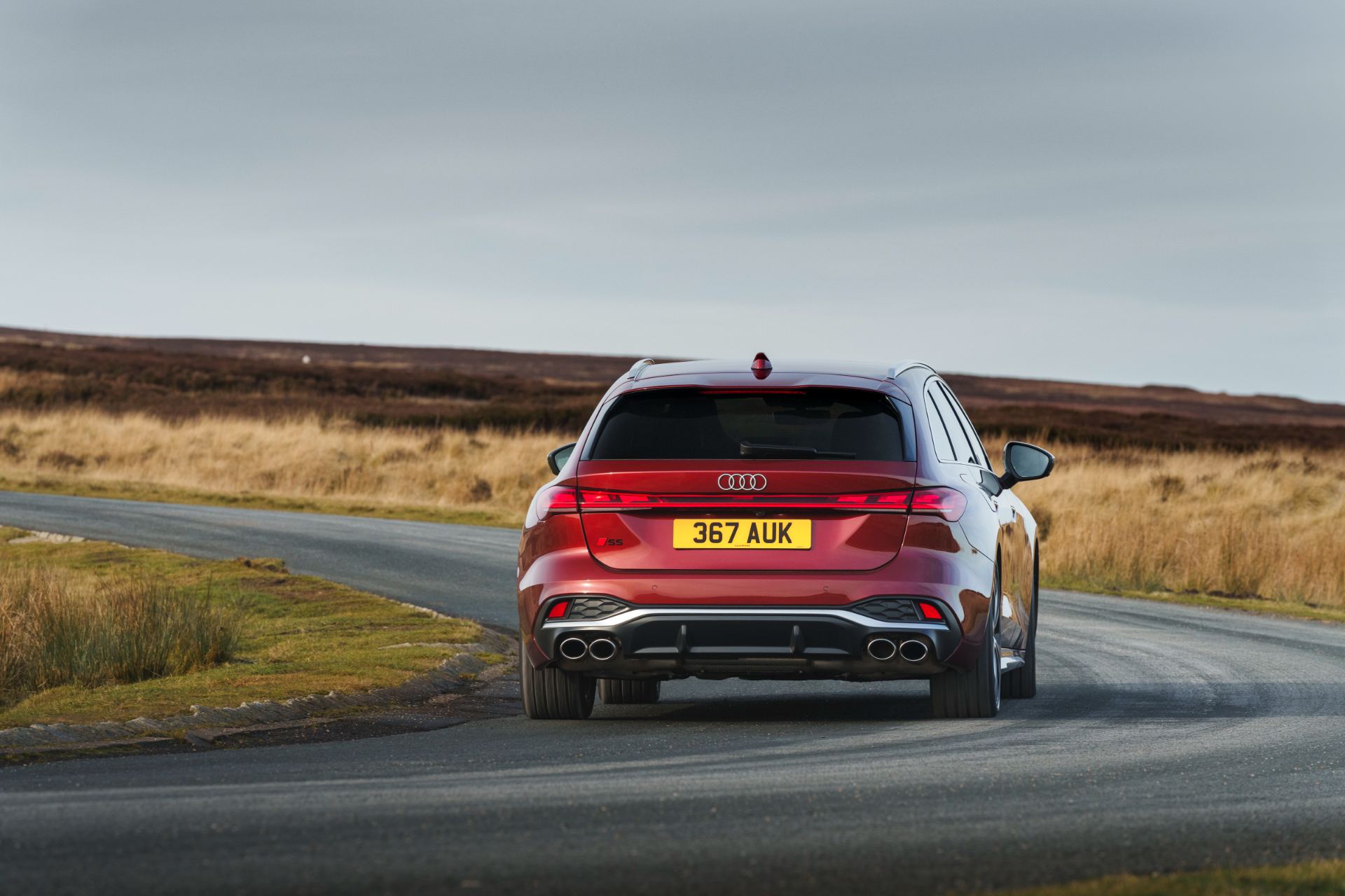 2026 audi s5 avant driving rear moorland road red
