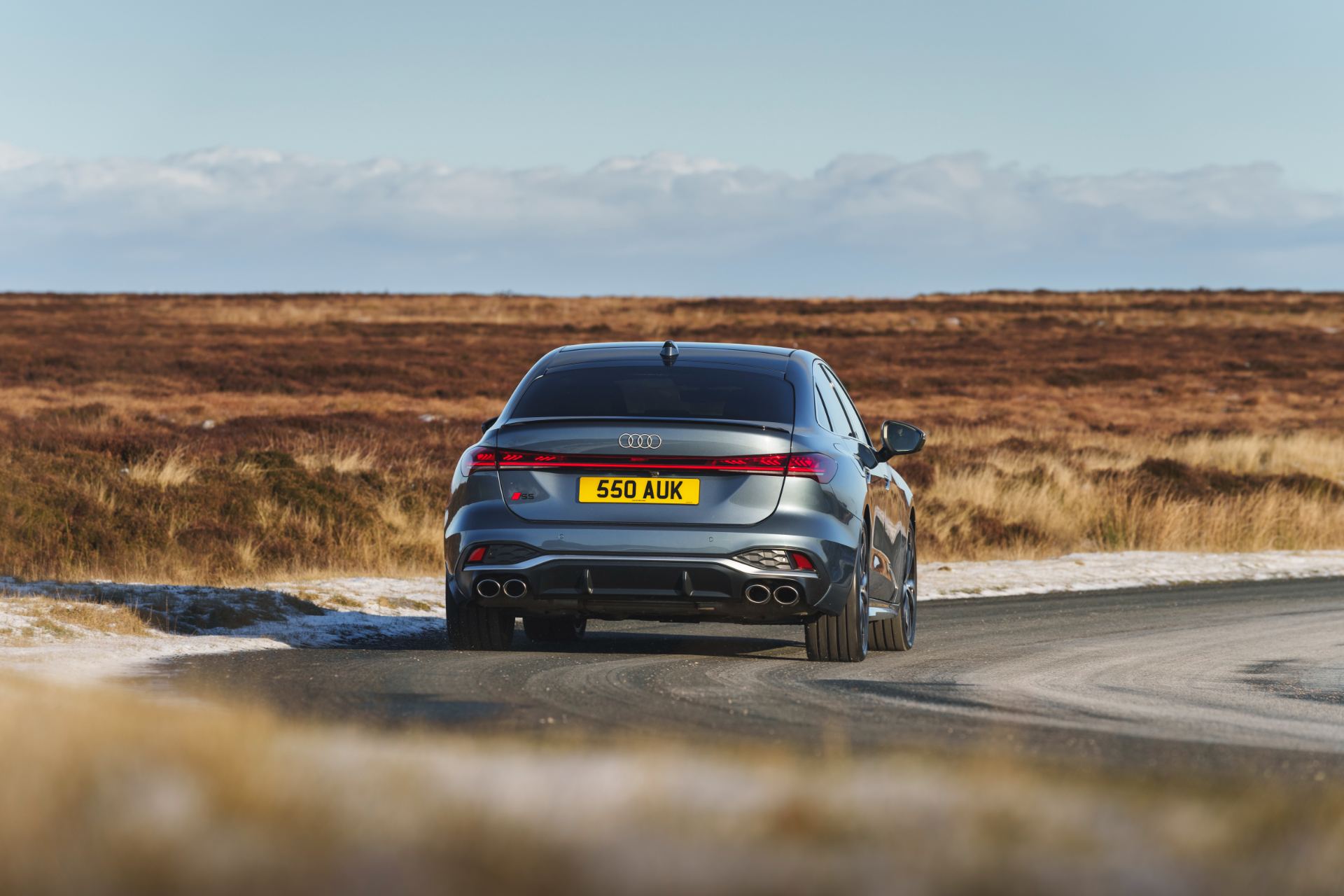 2026 audi s5 saloon driving rear moorland road grey