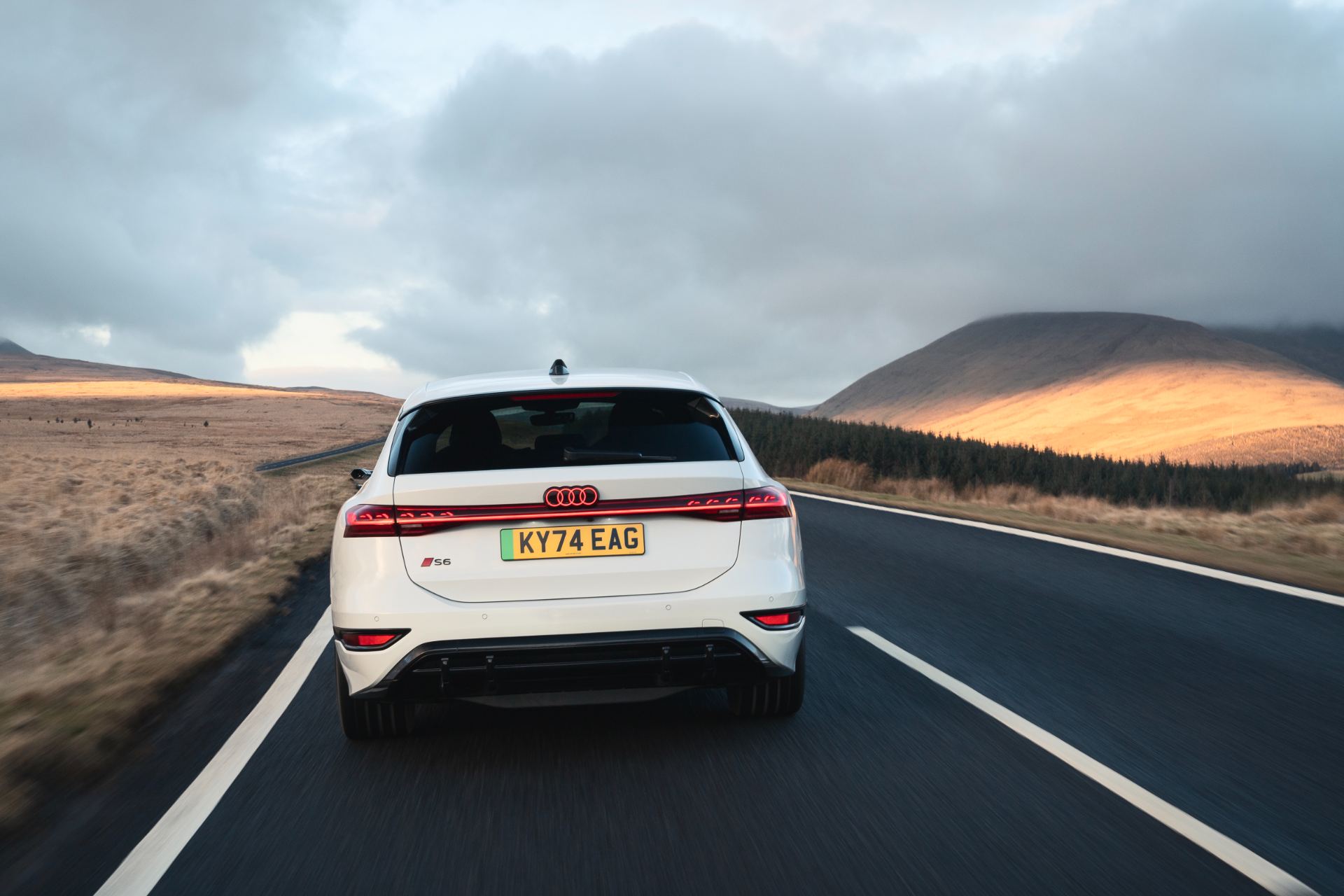 2026 audi s6 avant e tron driving rear moorland road white