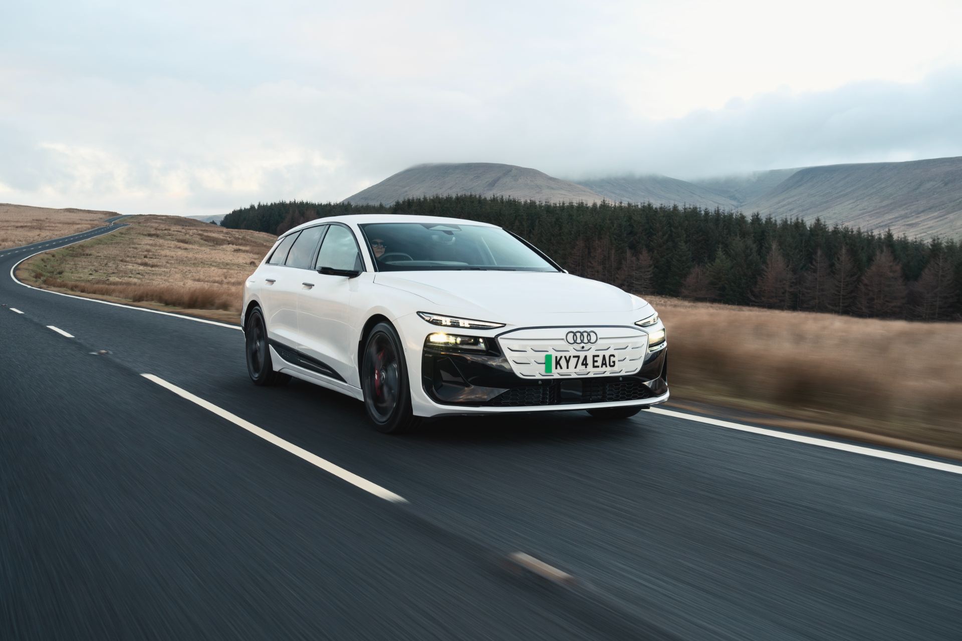 2026 audi s6 avant e tron driving front three quarter moorland road white