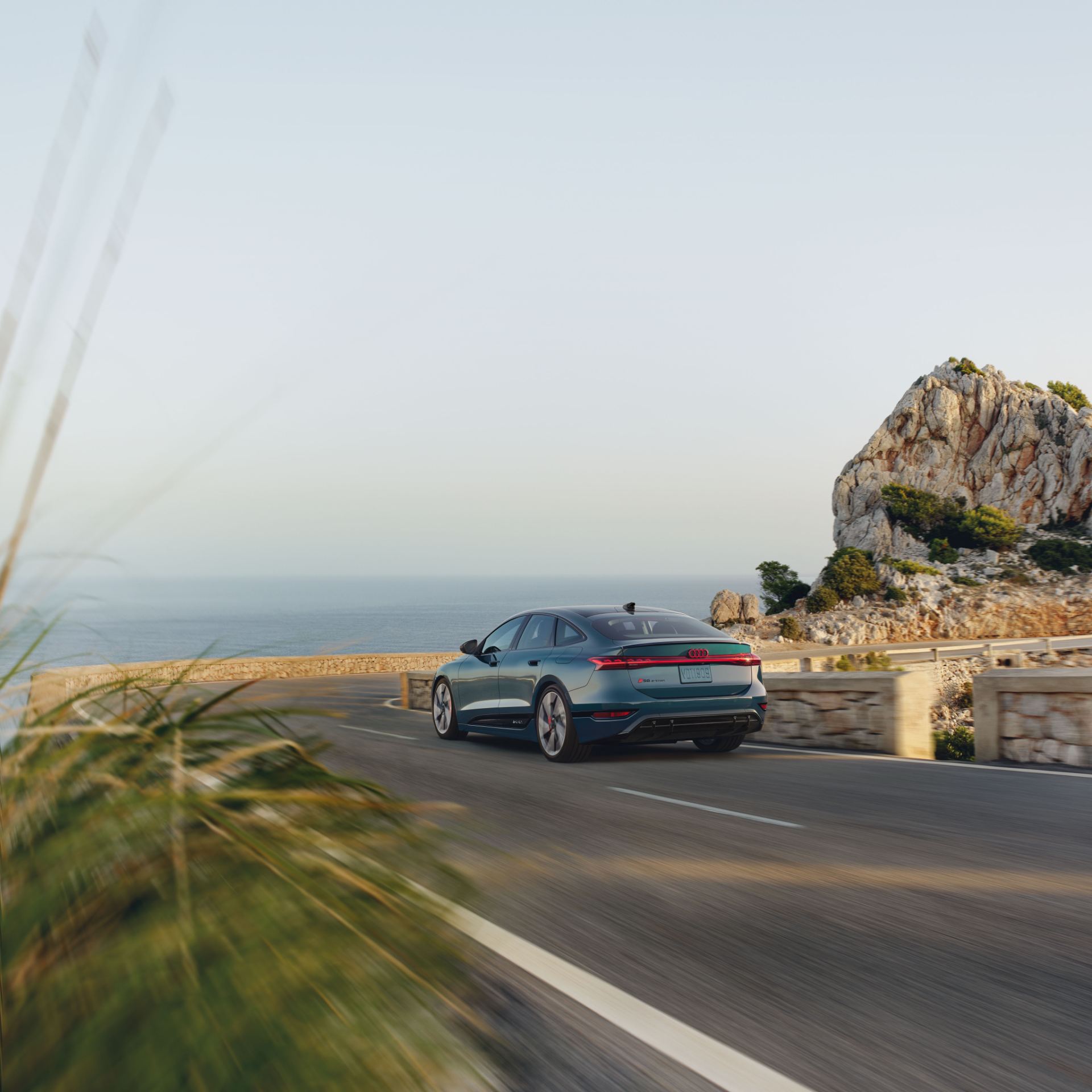 2027 audi s6 sportback e tron driving rear coastal road teal