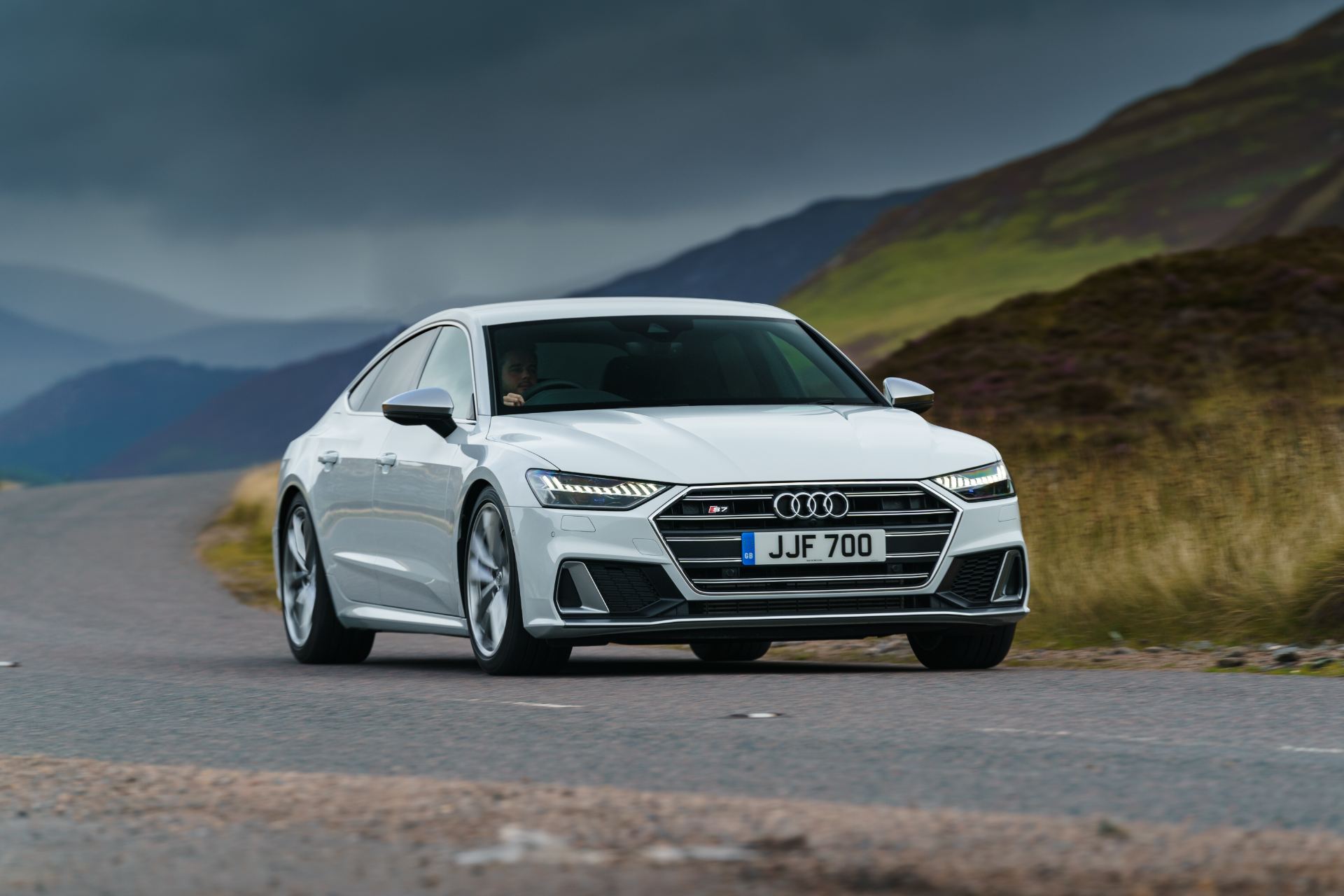 audi s7 sportback driving front three quarter mountain road white