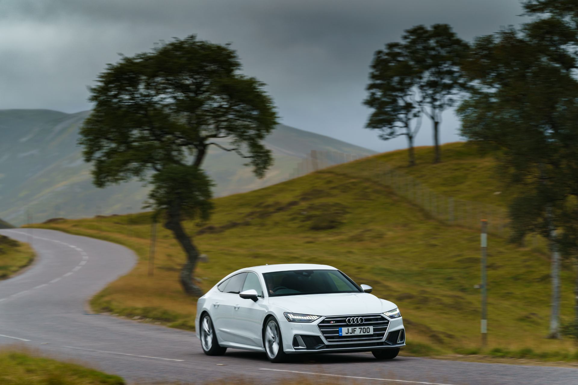 audi s7 sportback driving front winding road tree white