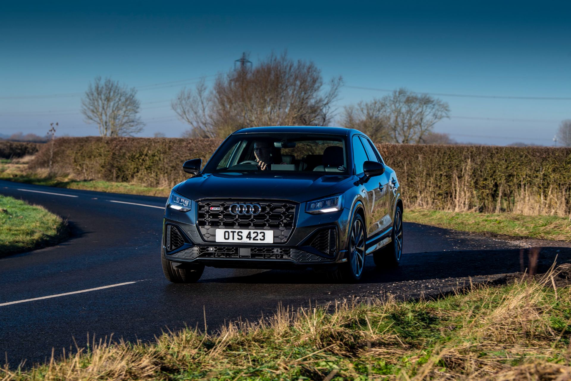 2025 audi sq2 driving front three quarter country road grey