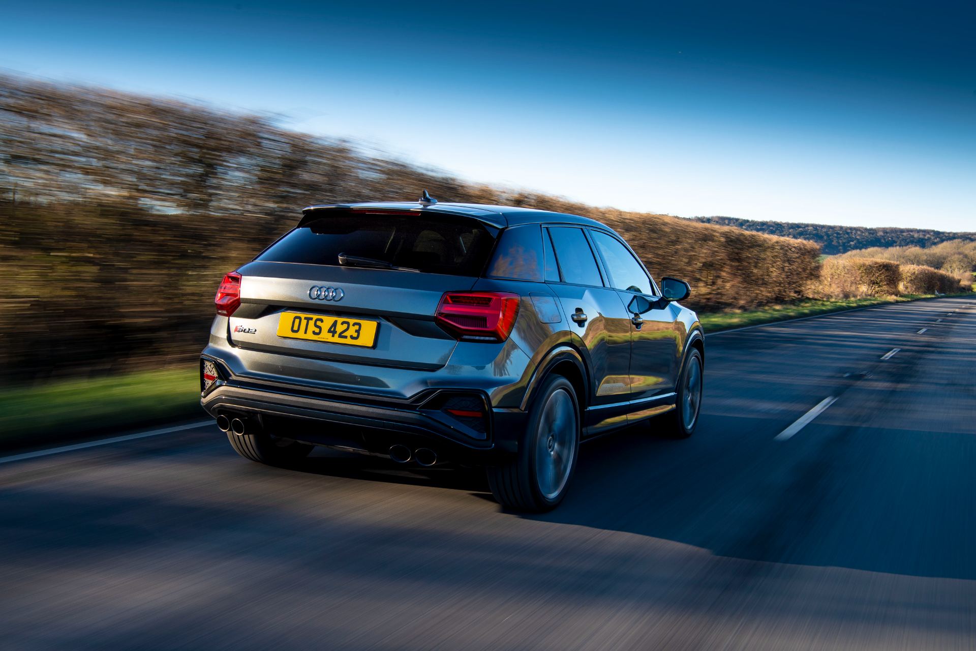2025 audi sq2 driving rear three quarter hedgerow grey