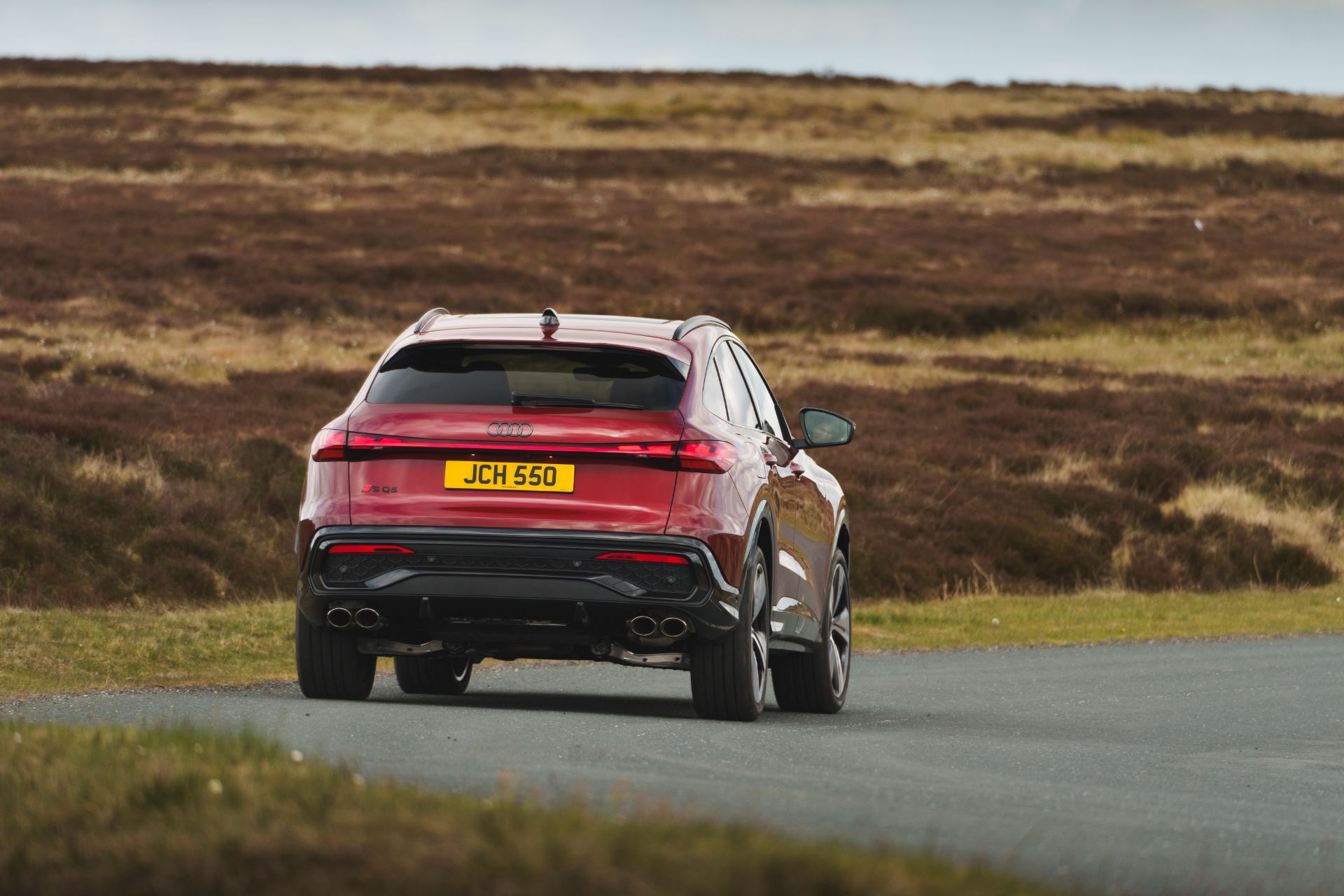 2026 audi sq5 sportback driving rear moorland red