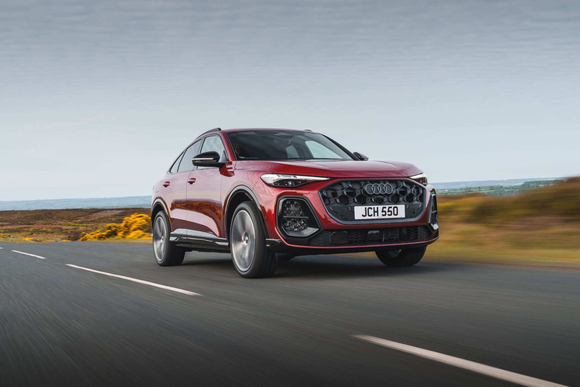 2026 audi sq5 sportback driving front three quarter gorse red