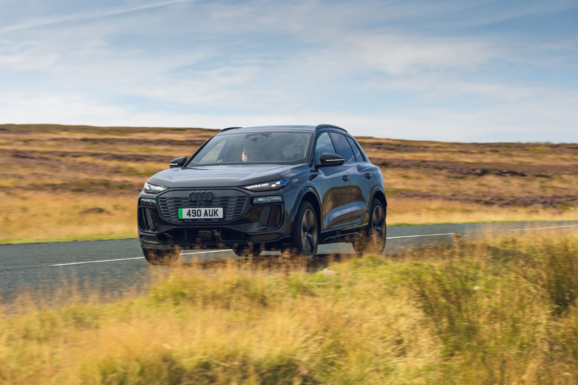 2026 audi sq6 e tron driving front three quarter grass grey