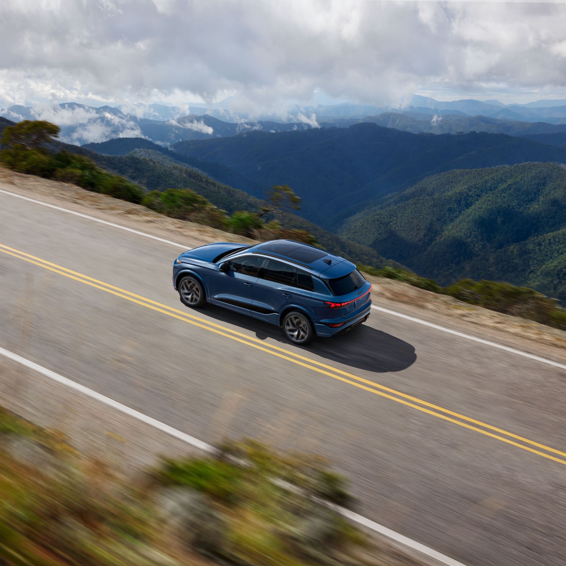 2027 audi sq6 e tron driving high angle mountain road blue