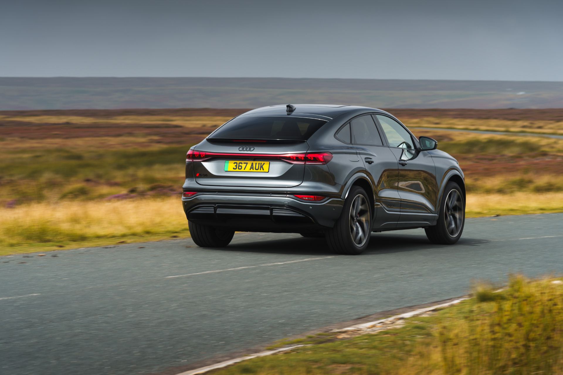 2026 audi sq6 sportback e tron driving rear three quarter grey