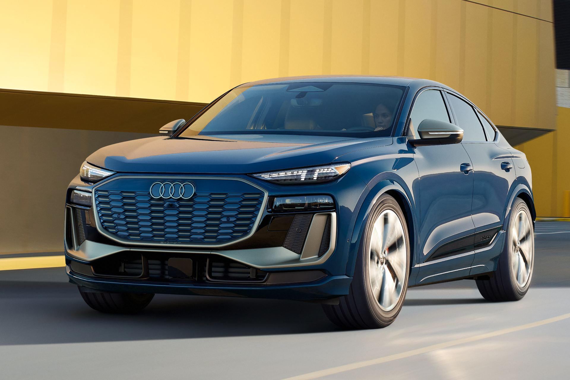 2027 audi sq6 sportback e tron driving front three quarter gold wall blue