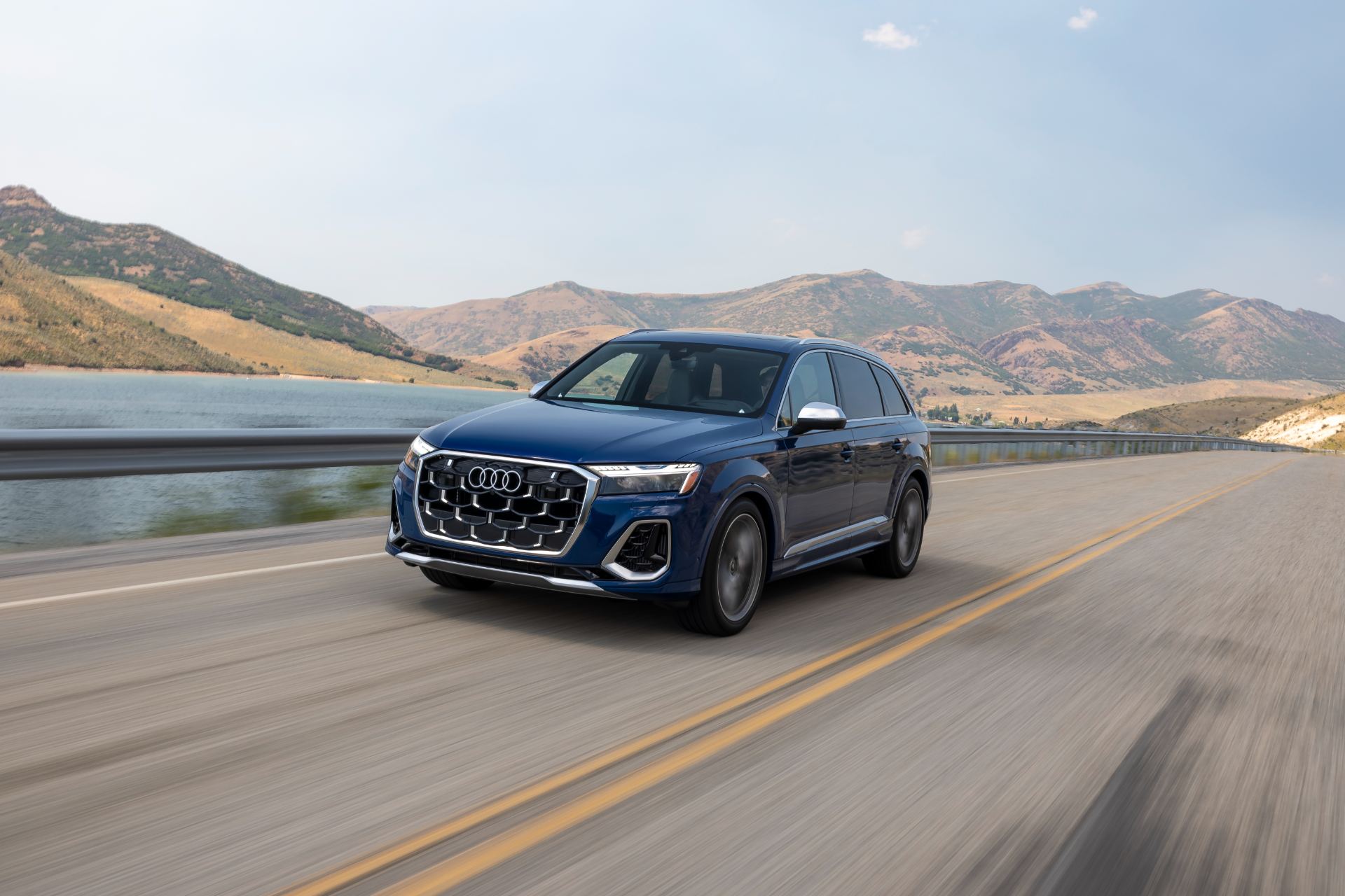 audi sq7 driving front three quarter lake road blue