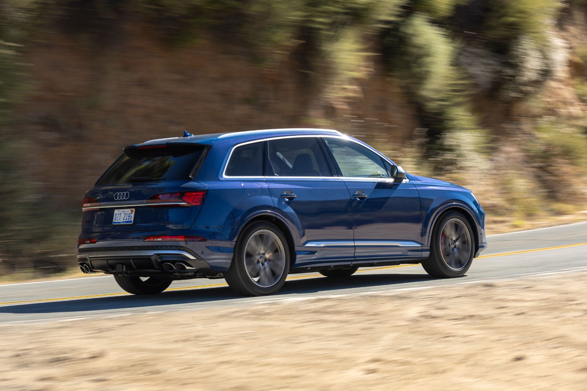 audi sq7 driving rear three quarter canyon road blue
