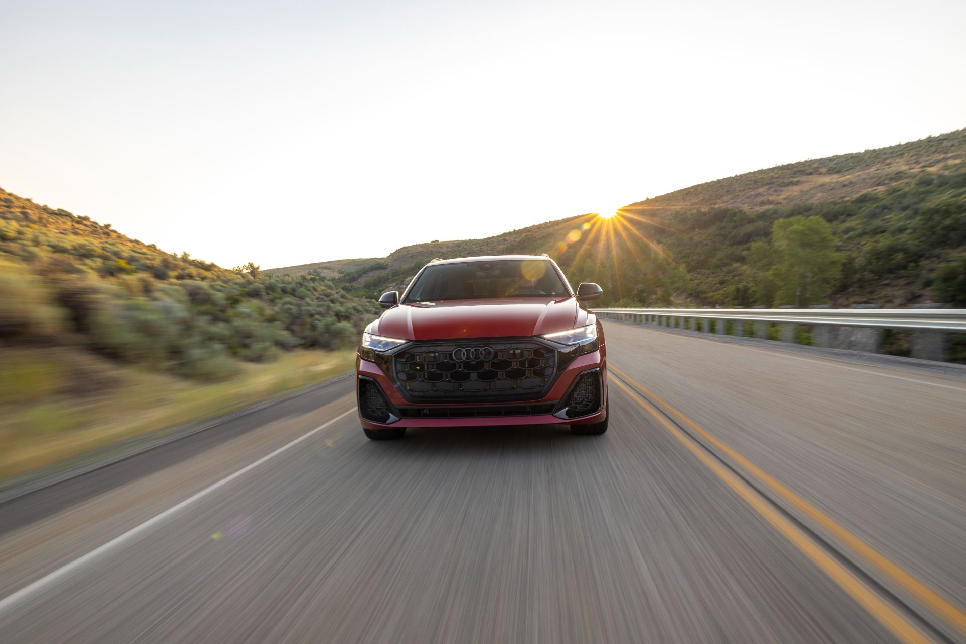 audi sq8 driving front highway sunset red