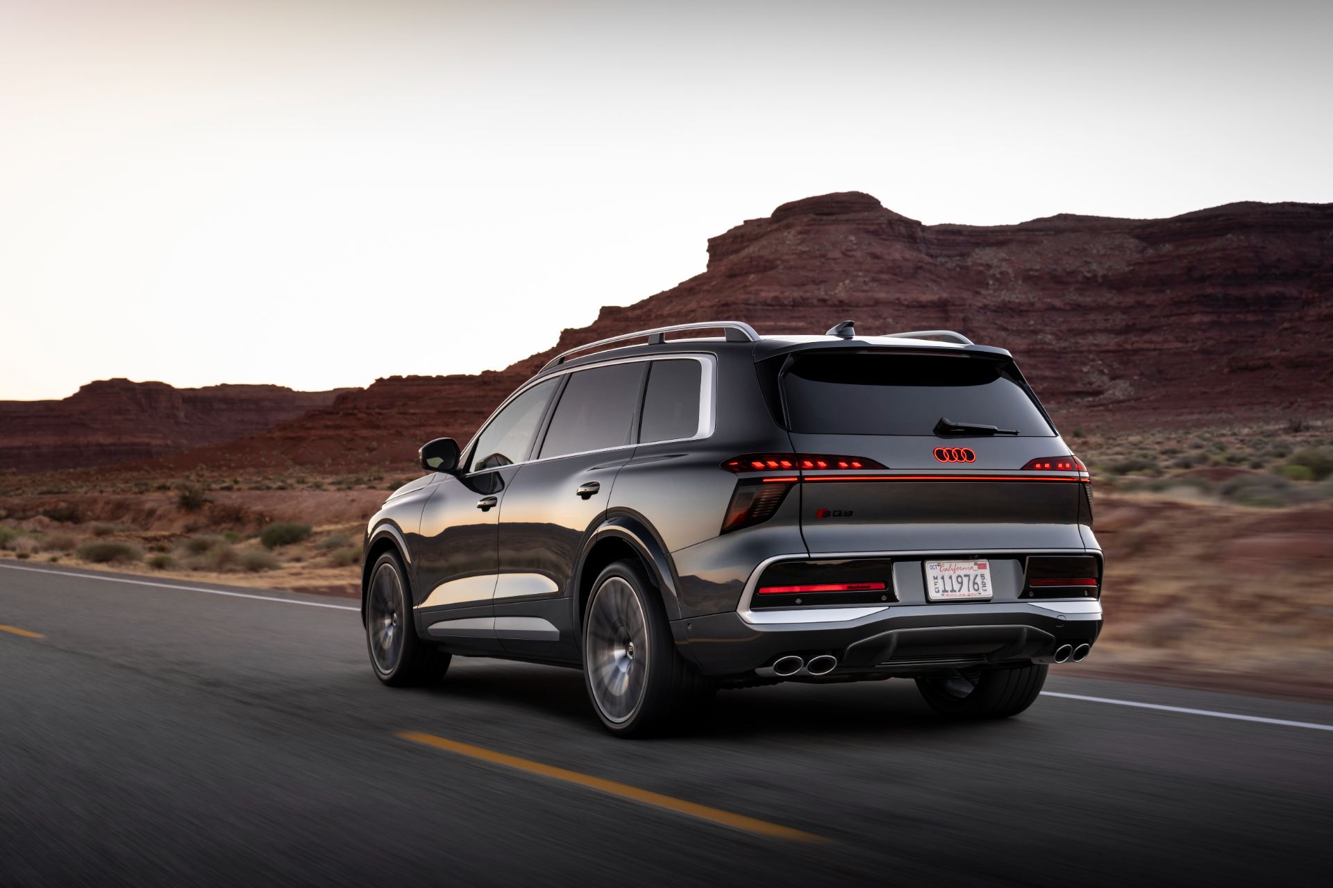 2027 audi sq9 driving rear three quarter desert grey