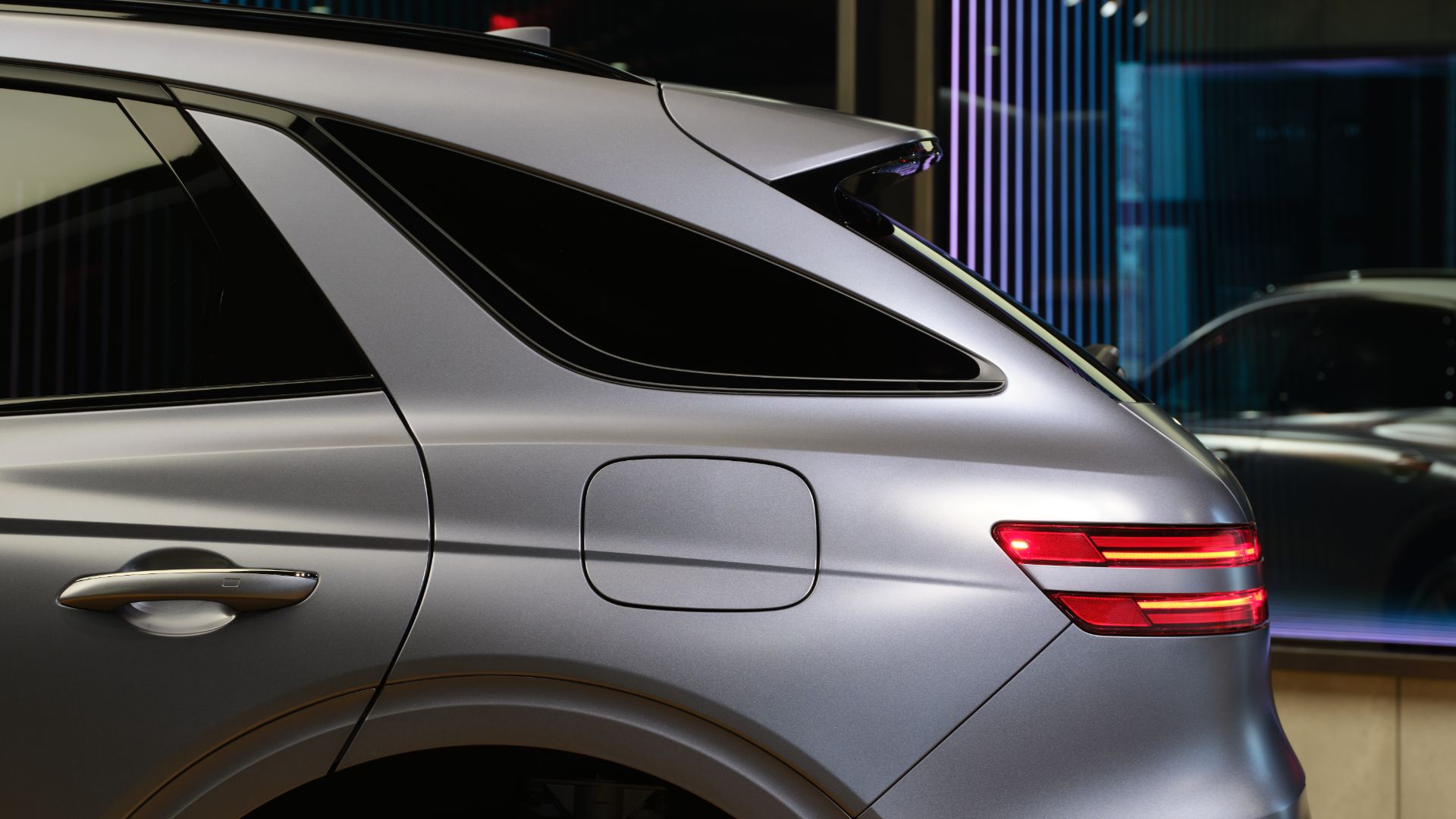 Rear three-quarter view of the 2026 GV70 Sport trim with reshaped exhaust outlets