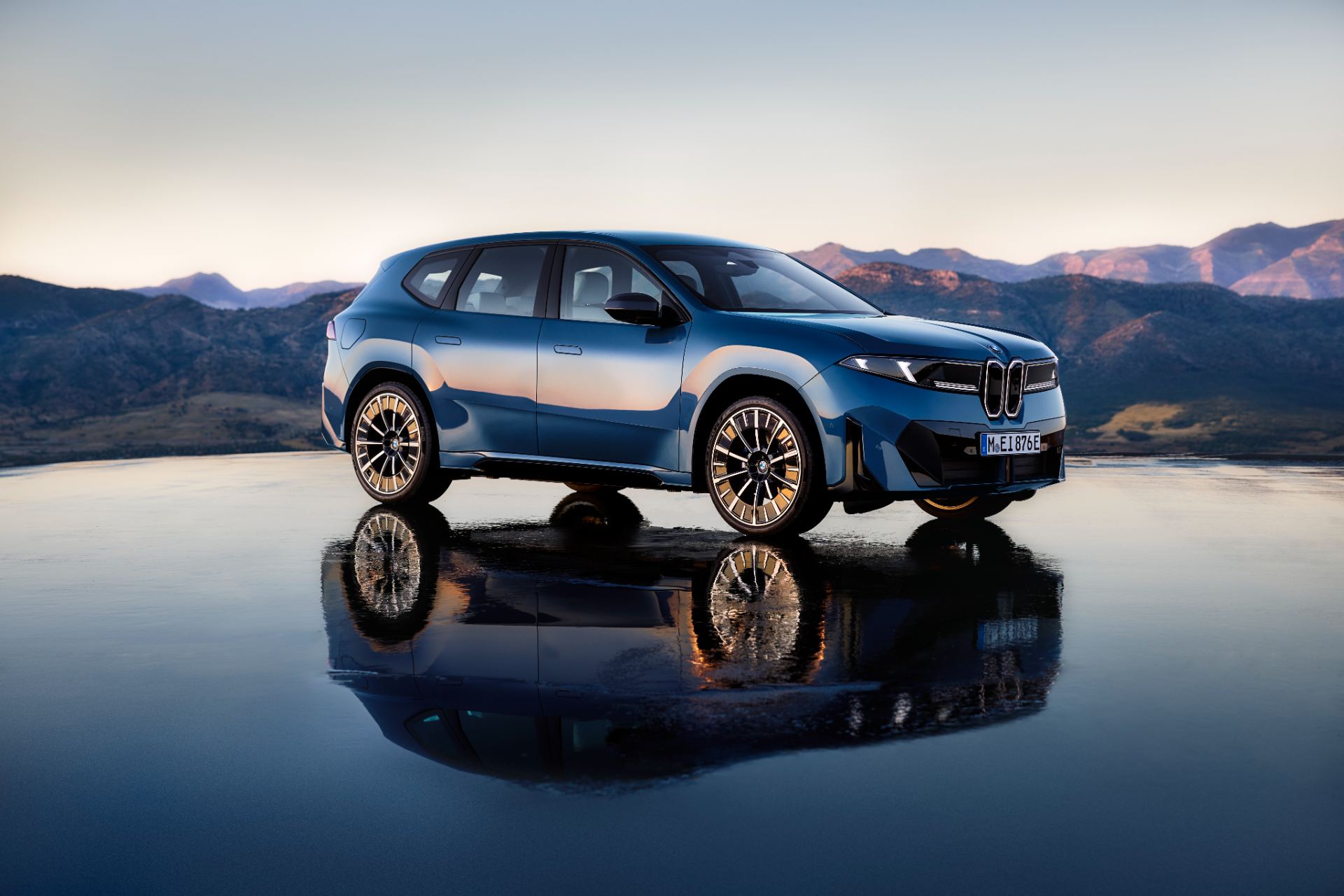 Front three-quarter exterior of the 2027 BMW iX3 50 xDrive in Ocean Wave Blue metallic, official BMW press photo on a neutral studio backdrop