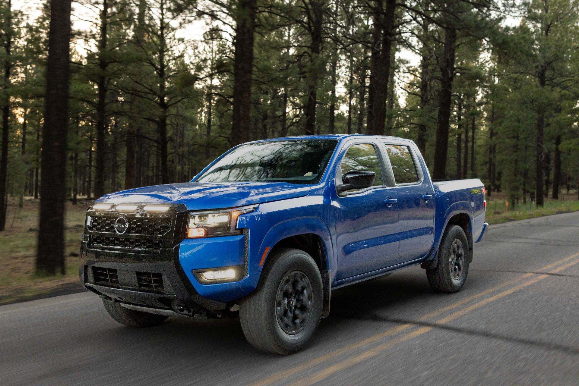 Front three-quarter of the 2027 Frontier Sport Edition showing the yellow accents and LED fog lights