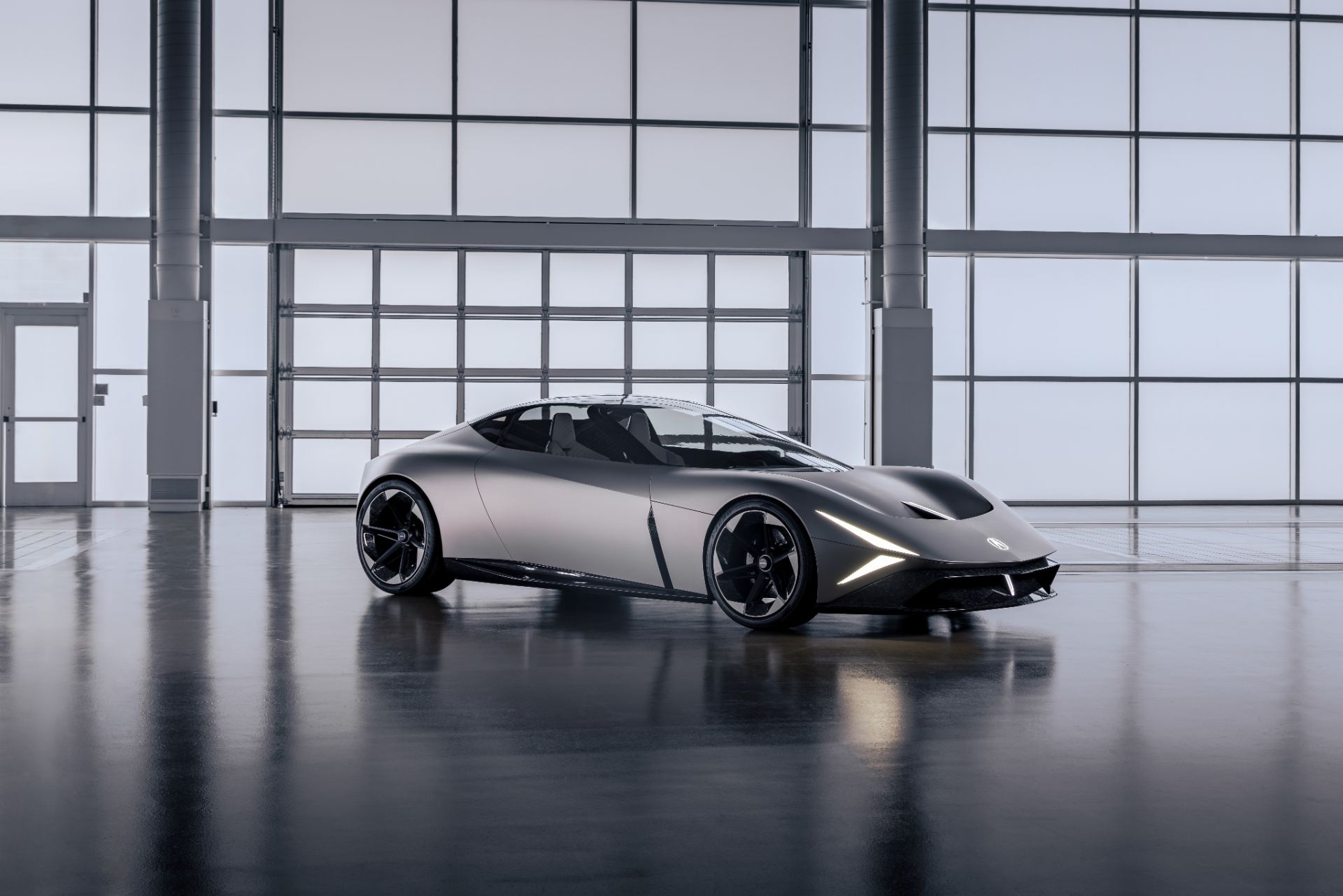 Front three-quarter in Matte Titanium showing the aero-channel fascia and wide stance, studio press photo